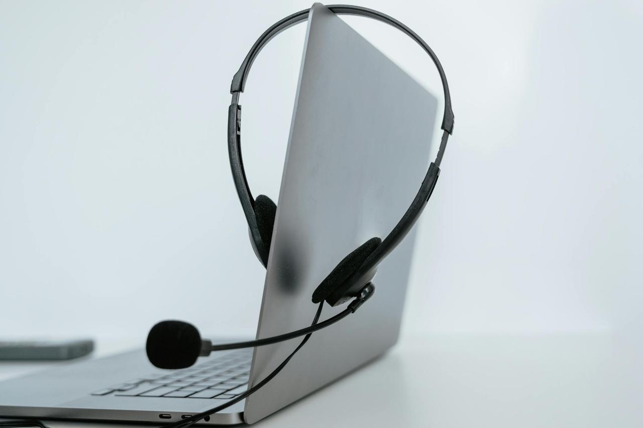 Close-up of a laptop with a headset, symbolizing remote work or online communication.
