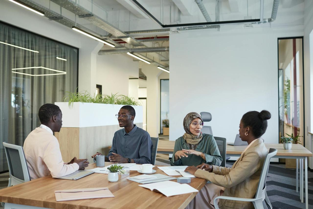 A diverse group of colleagues engaged in a meeting at a modern office workspace.