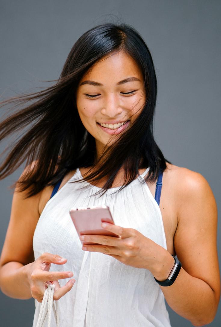 canva - woman using a phone while carrying a bag.jpg
