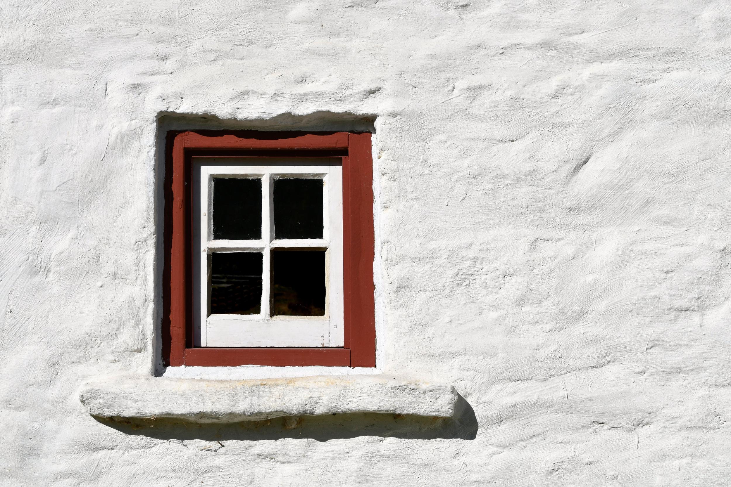 a-white-wall-with-a-red-trim-window-in-an-adobe-st-2022-11-14-03-44-38-utc.jpg