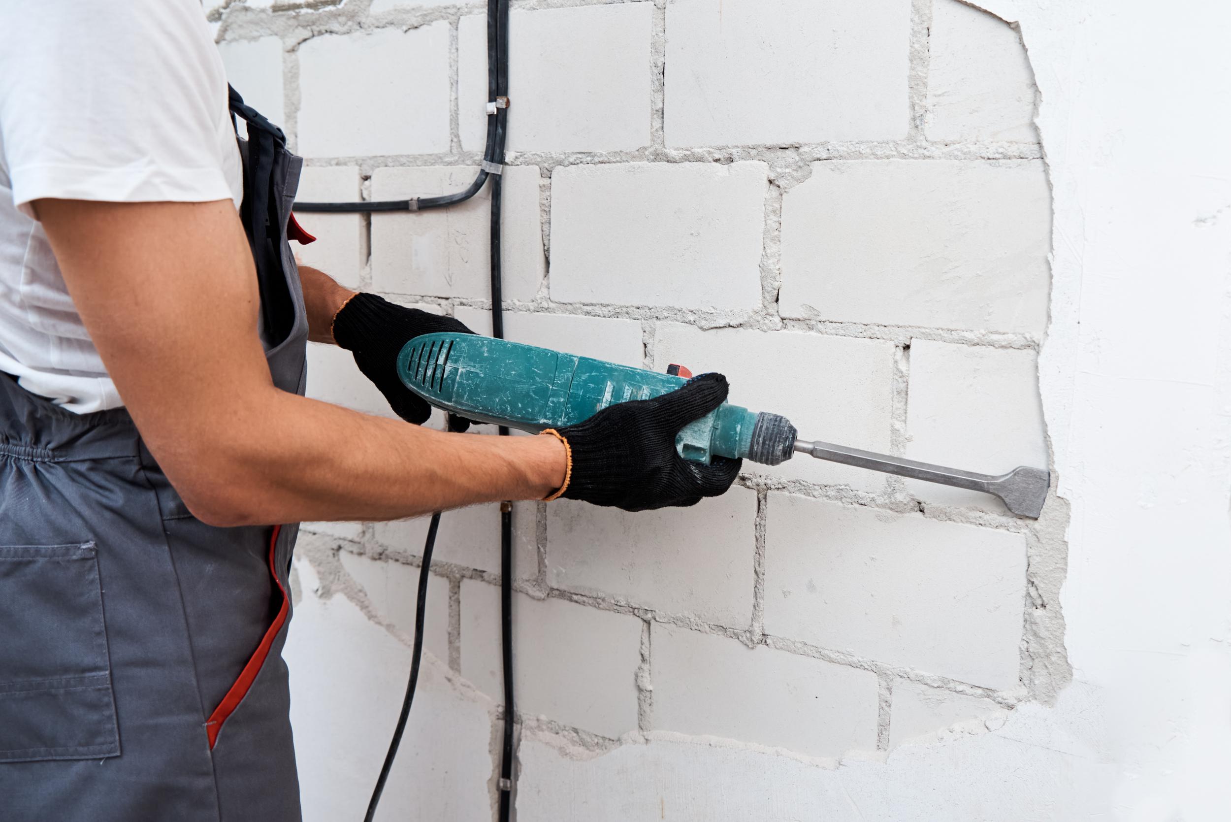 man-with-demolition-hammer-remove-stucco-from-wall-2022-12-16-12-39-49-utc.jpg