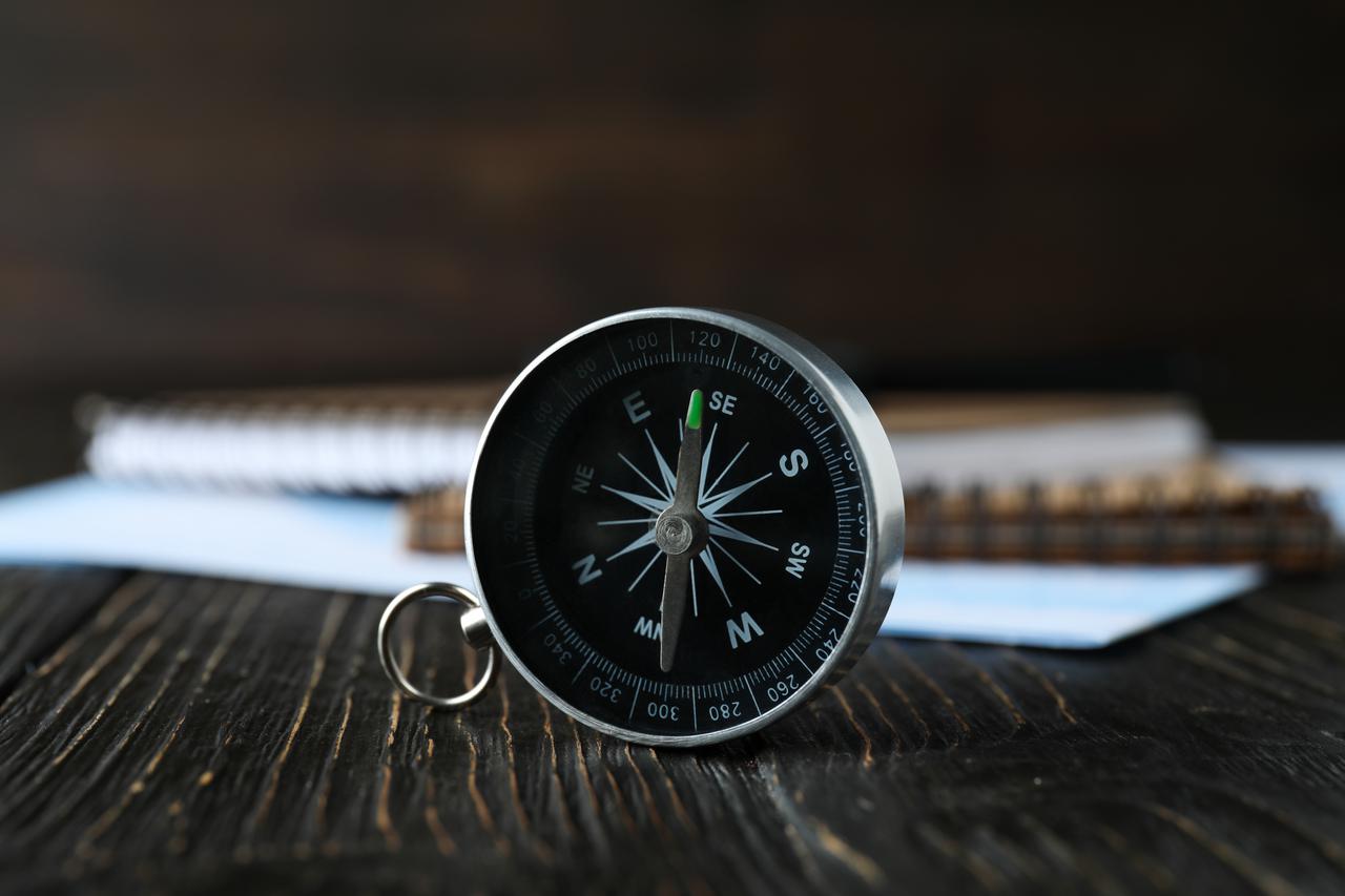 a-compass-on-a-table-with-an-airplane-2025-03-25-22-20-09-utc.jpg
