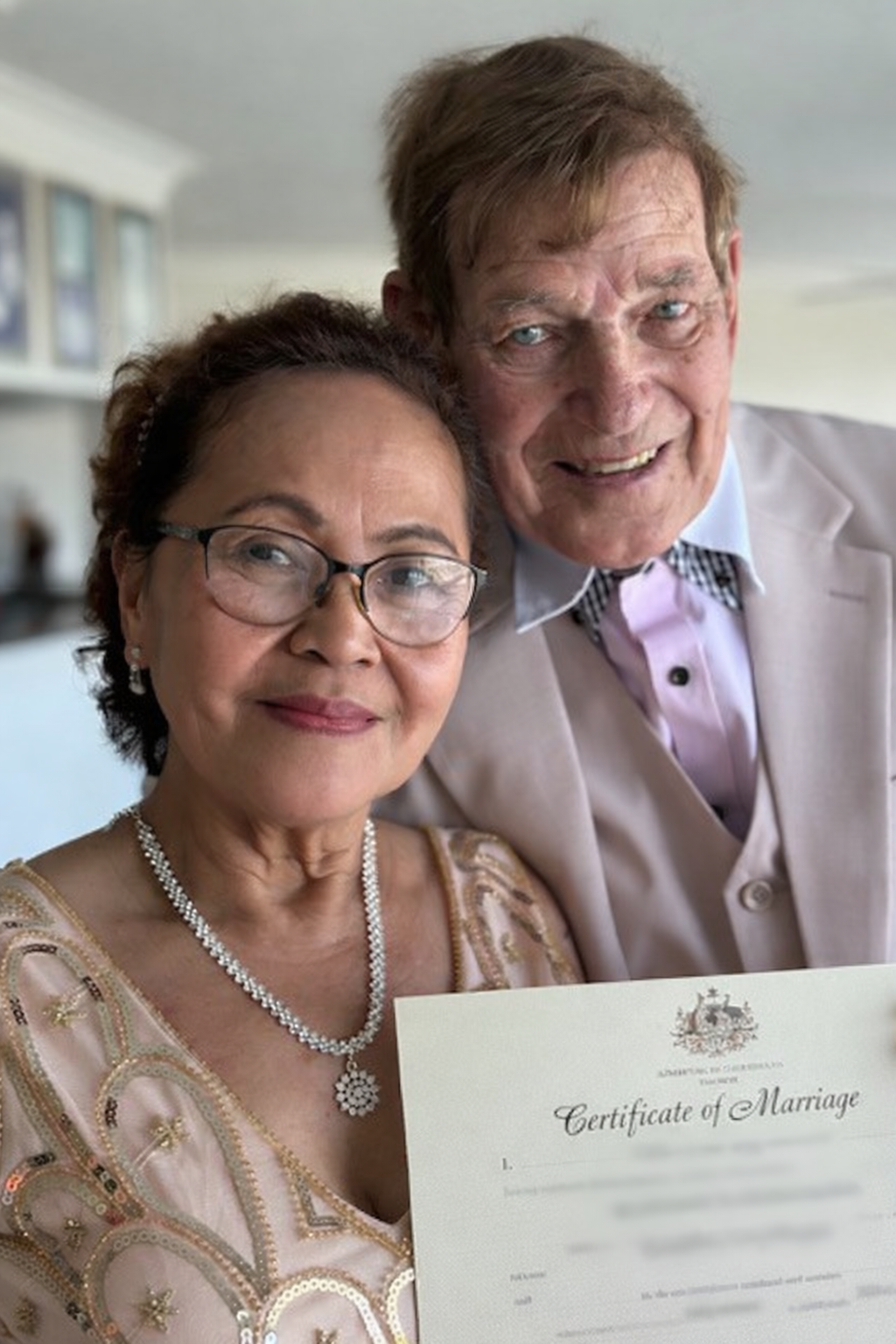 newlyweds with their marriage certificate.png