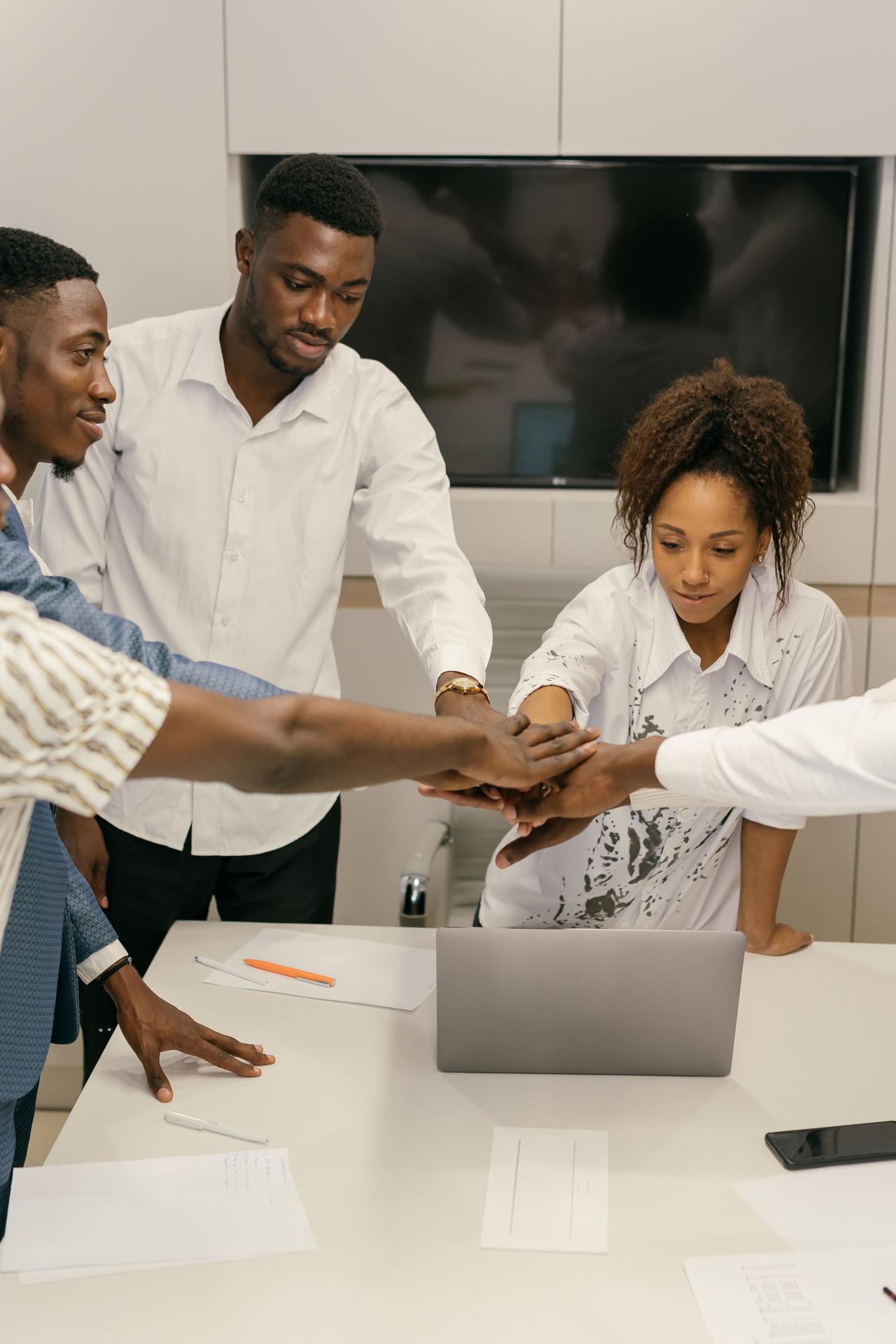 Professional team of diverse individuals collaborating in an office setting, showing teamwork and unity.