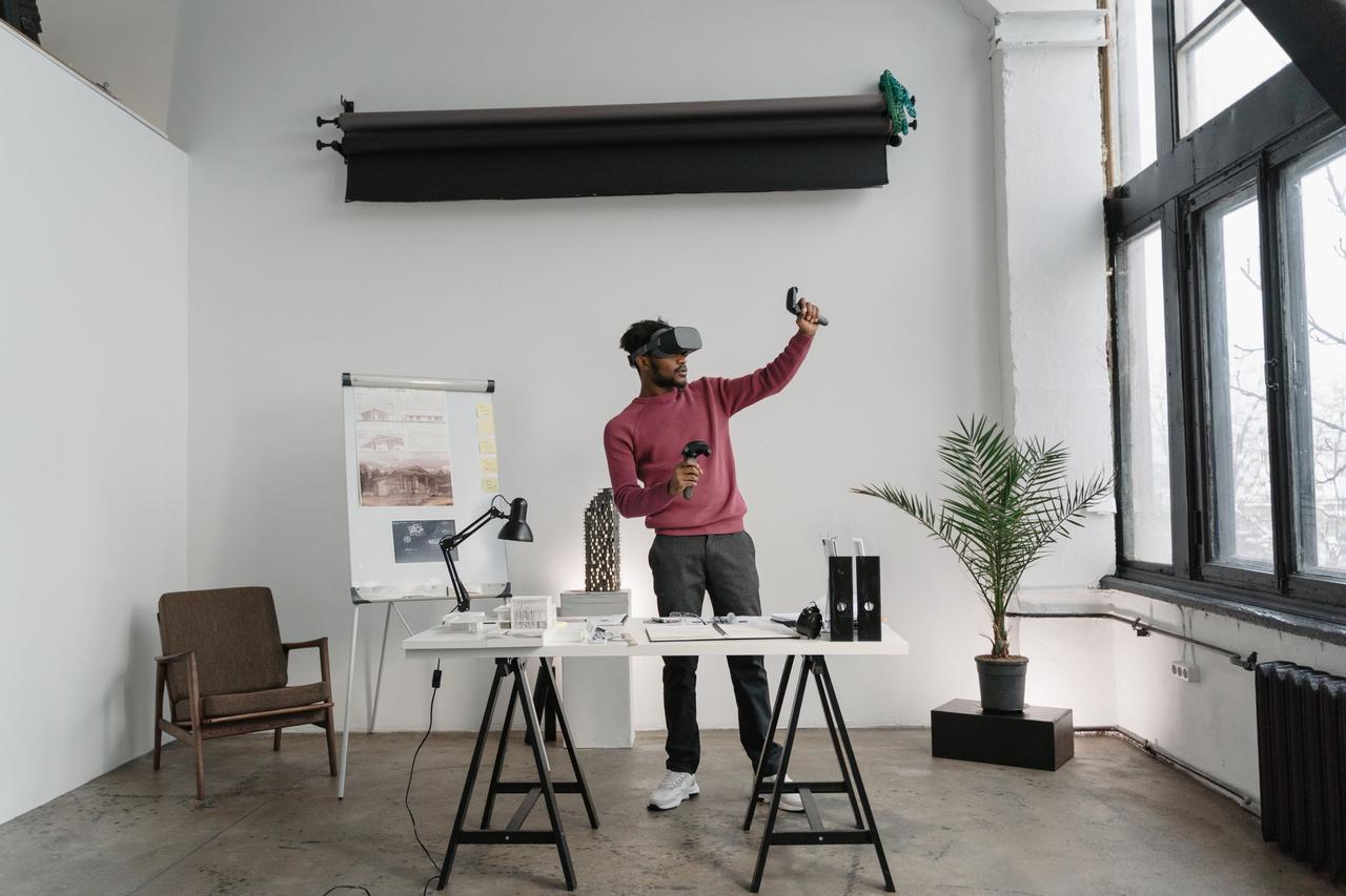 An adult man using VR glasses in a modern office environment for interactive work.