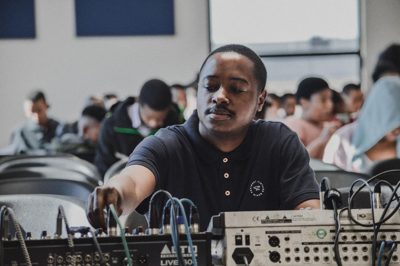 Man adjusting audio equipment in a classroom setting during a training session.