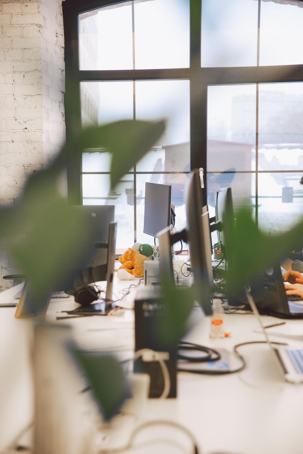 Contemporary office interior with blurred foreground and natural lighting through large windows.