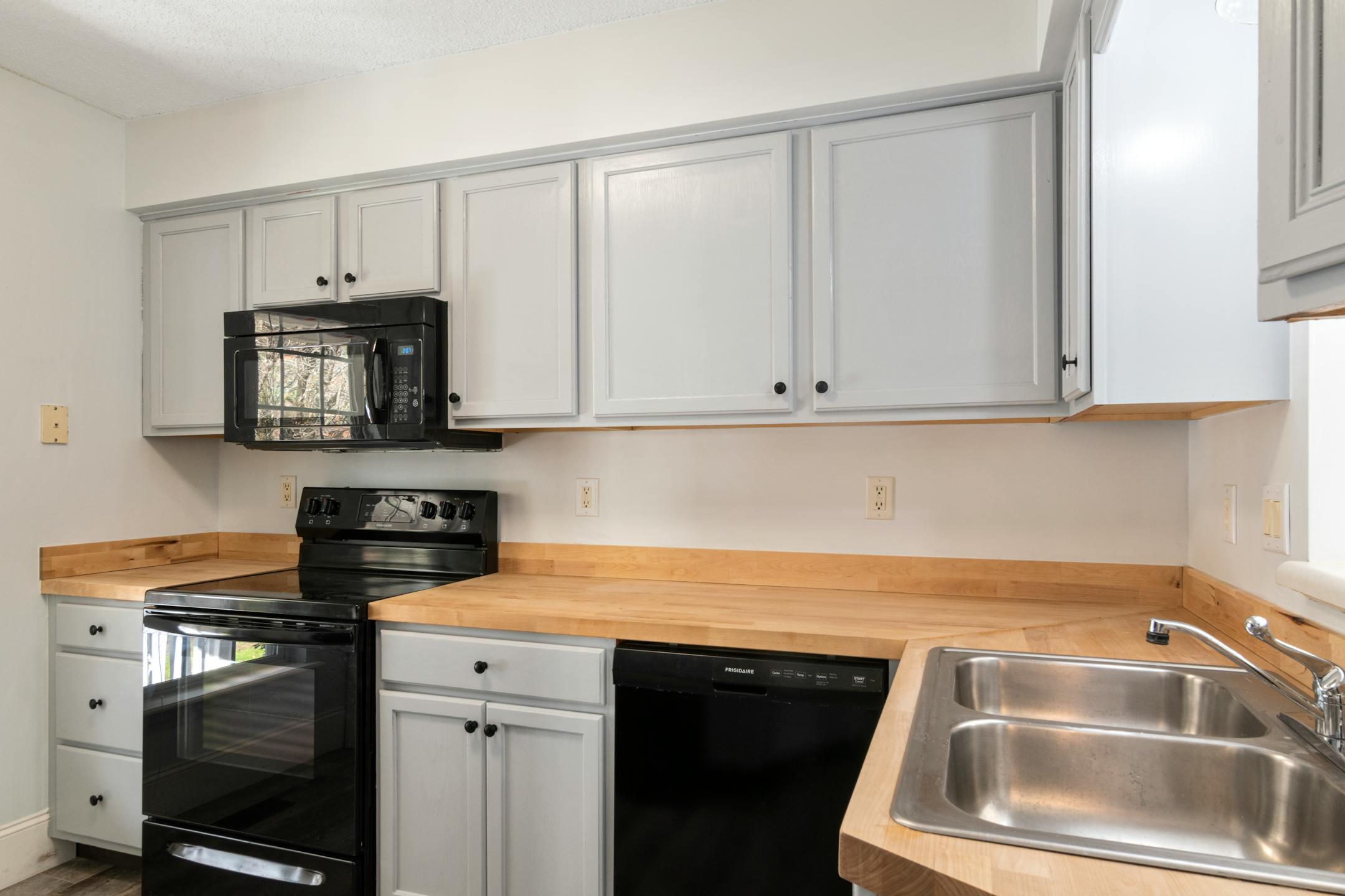 A modern kitchen featuring stainless steel sink and appliances with minimalist design.