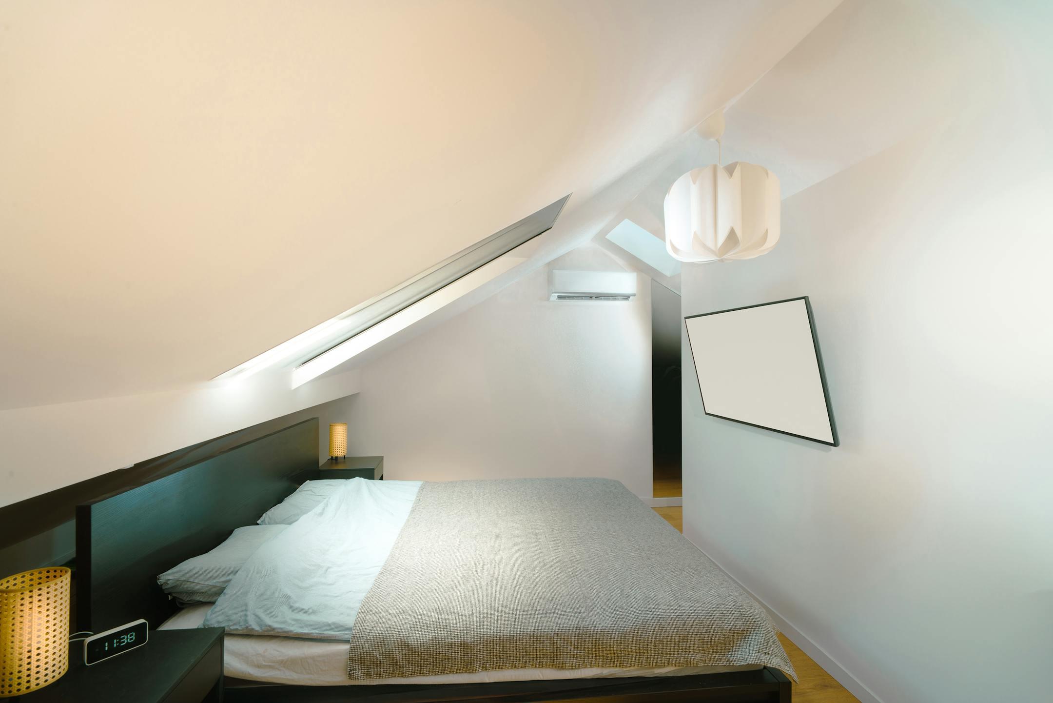 A sleek and minimalist attic bedroom with modern furnishings and natural lighting.