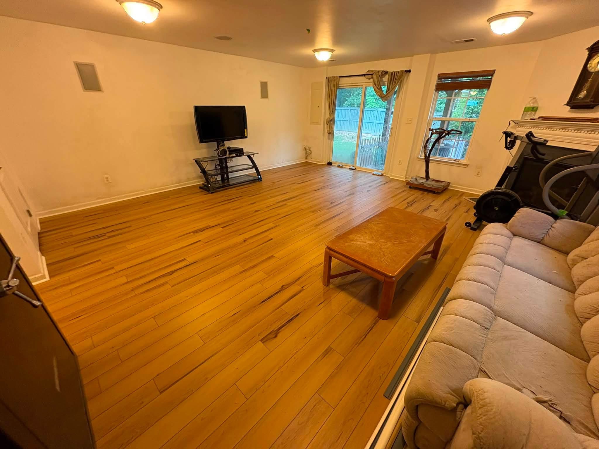 Freshly refinished wood flooring in a bright, renovated living space