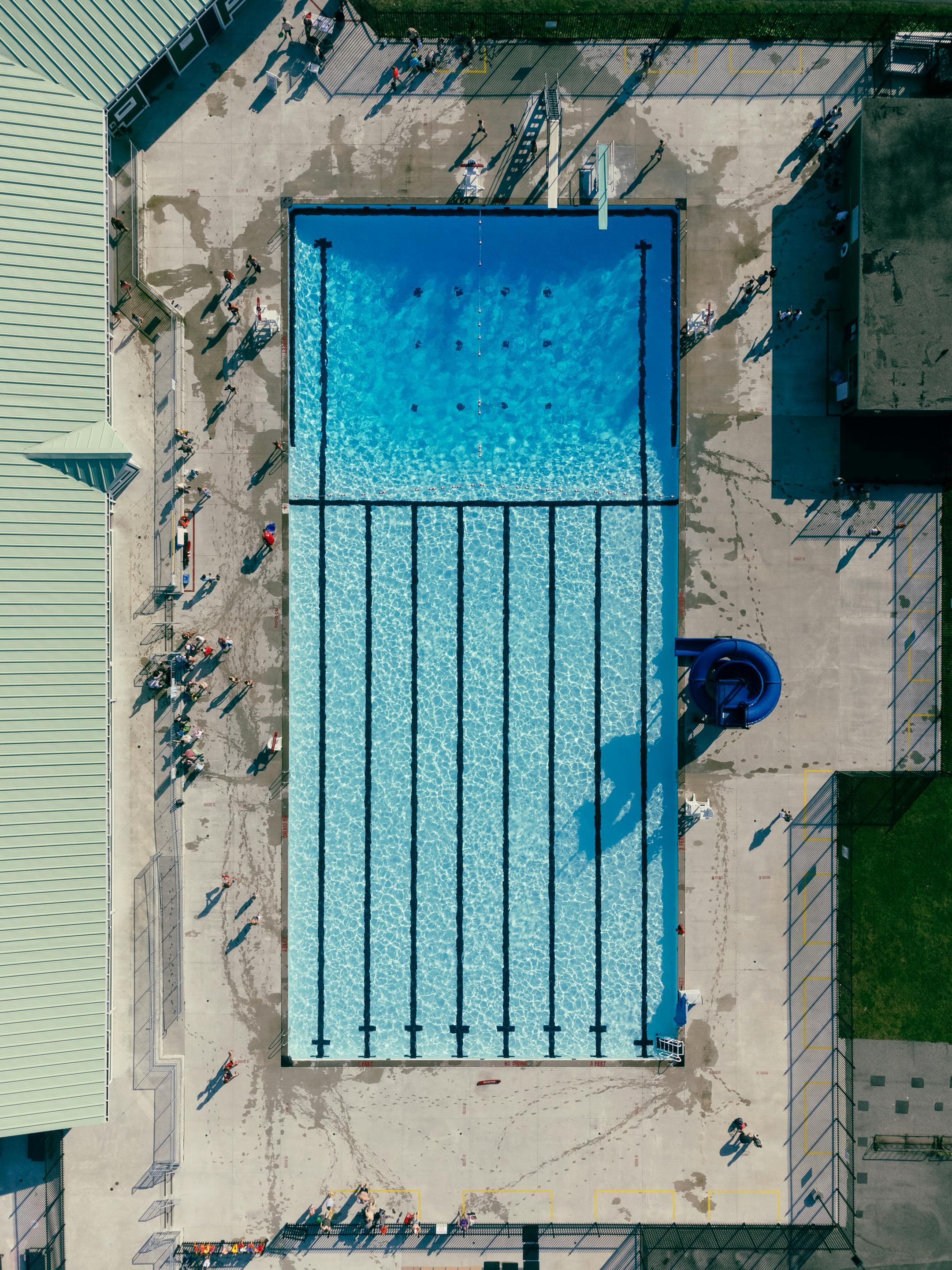High-angle shot of an outdoor swimming pool on a sunny day, perfect for leisure activities.
