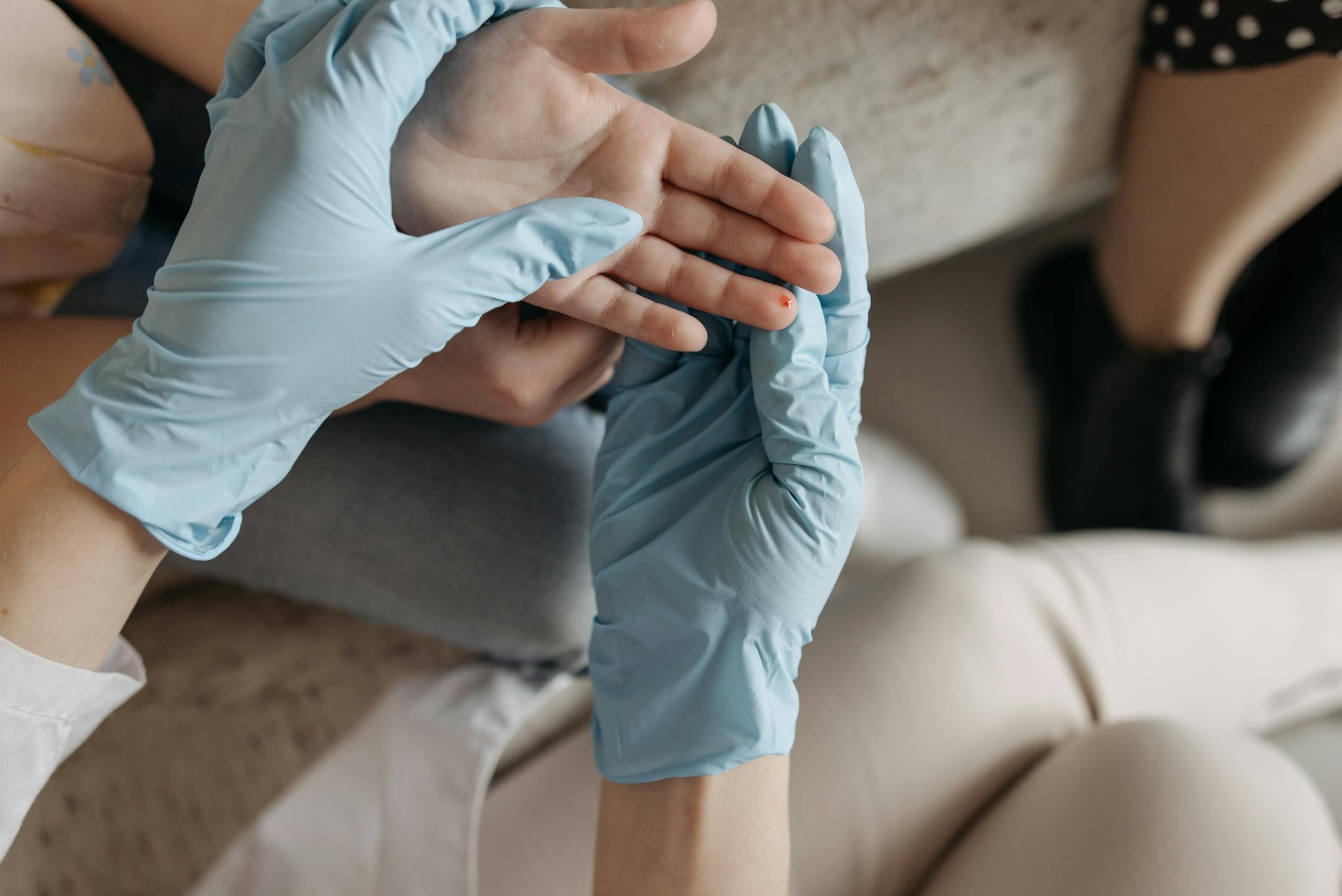 A medical professional wearing blue gloves performing luxury wound care services at home