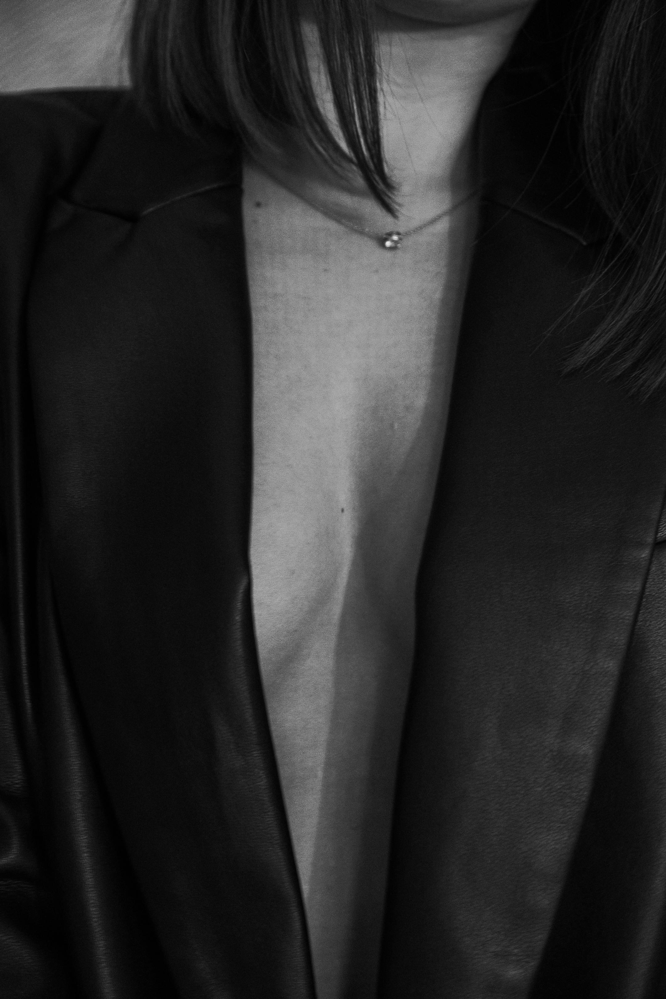 Elegant black and white portrait of a woman in a blazer showcasing minimalistic style.