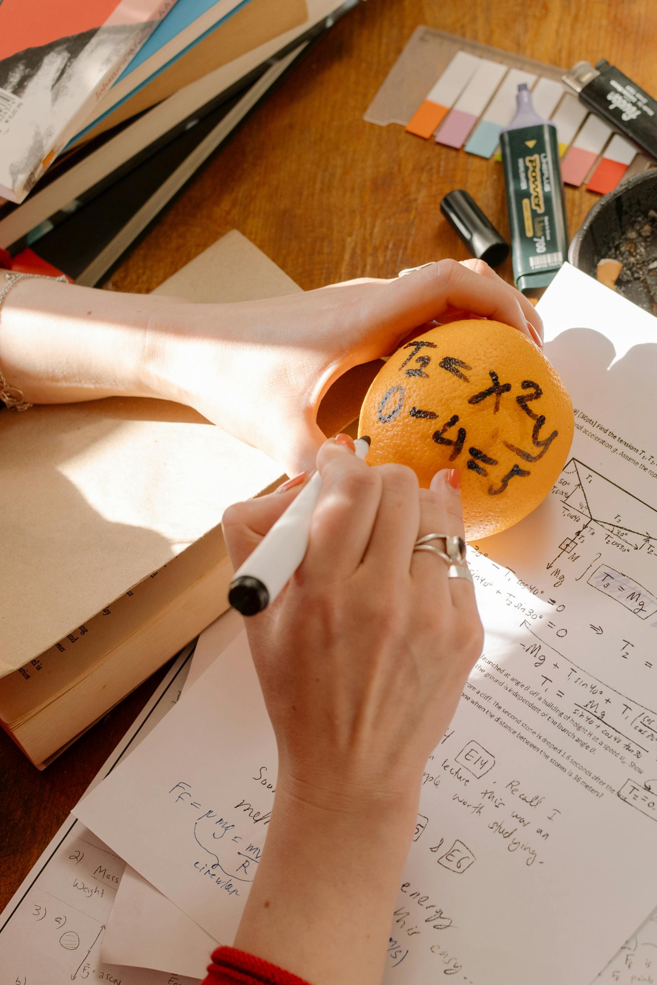 Innovative study session featuring math formulas written on an orange to enhance learning.