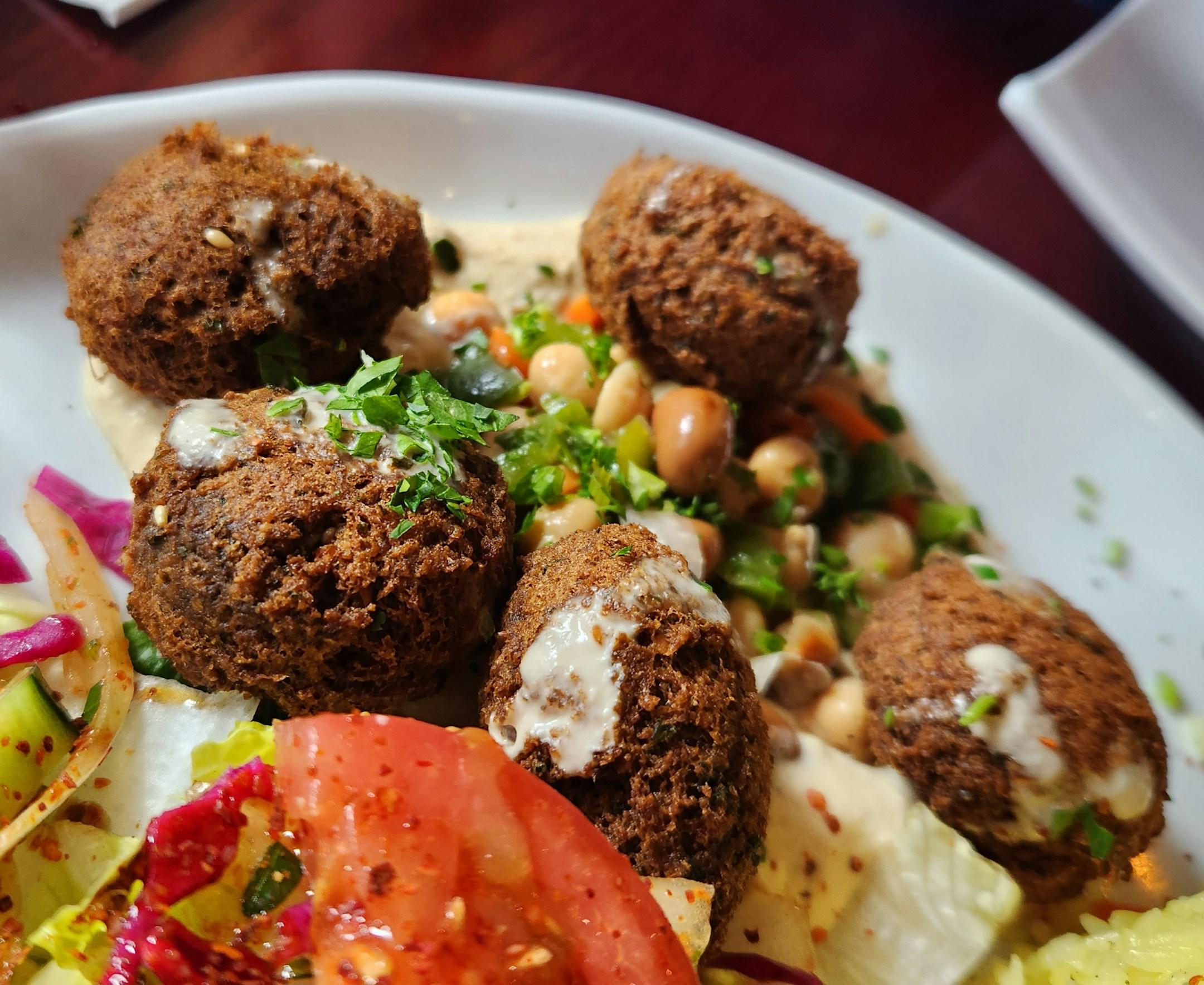 A hearty and delicious falafel served on a bed of fragrant rice - a satisfying and wholesome meal that will transport your taste buds to a world of bold flavors and exotic spices!