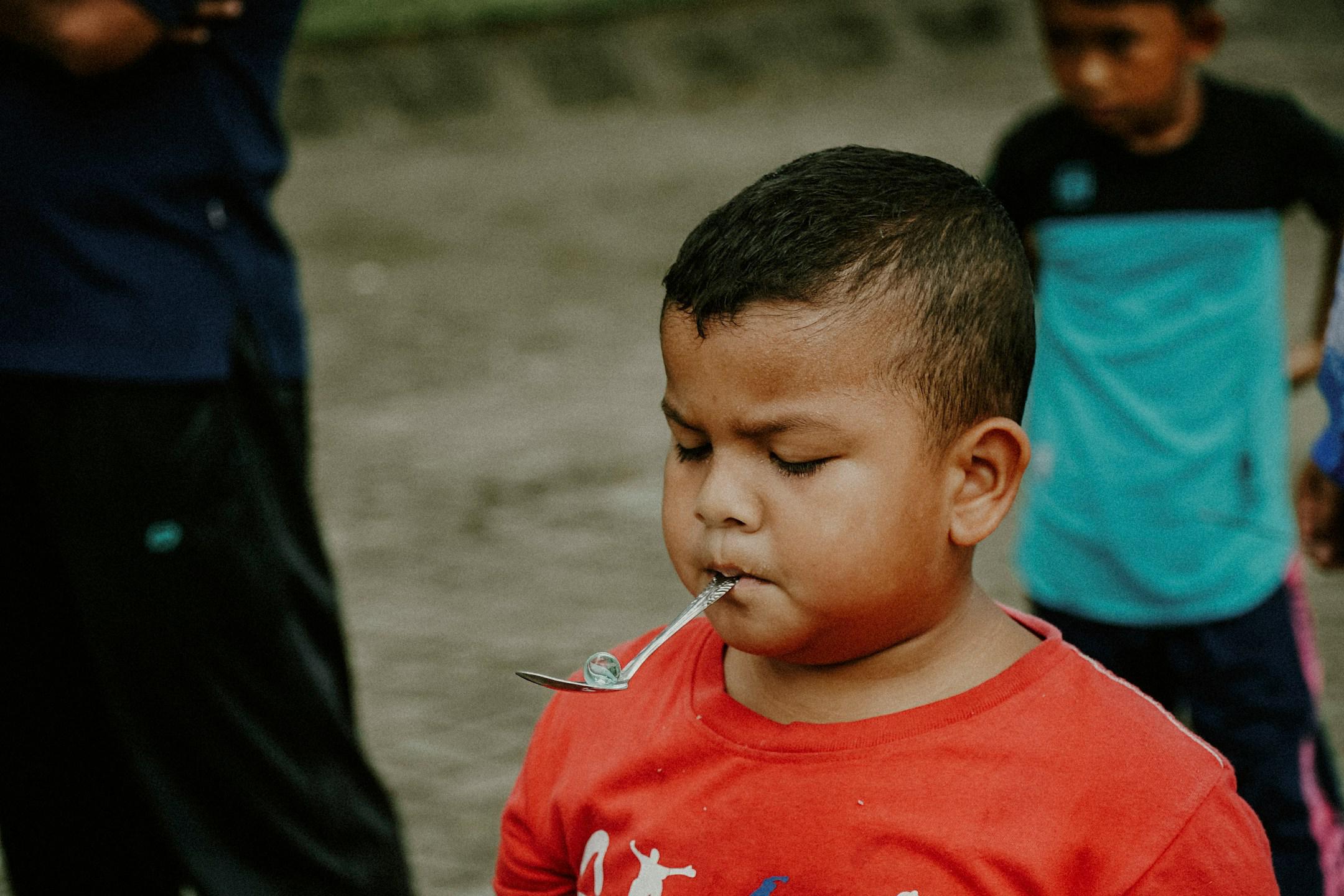 Immersed in the vibrant festivities of Indonesian Independence Day and World Photography Day, this candid shot captures a moment of pure joy. Amid the celebration, a child eagerly participates in a marbles racing competition, a beloved tradition that unites generations. The colorful outfits worn by the participants mirror the lively spirit of the event, while their smiles reflect the unity and happiness of the occasion. This snapshot encapsulates the essence of cultural heritage, youthful enthusiasm, and th
