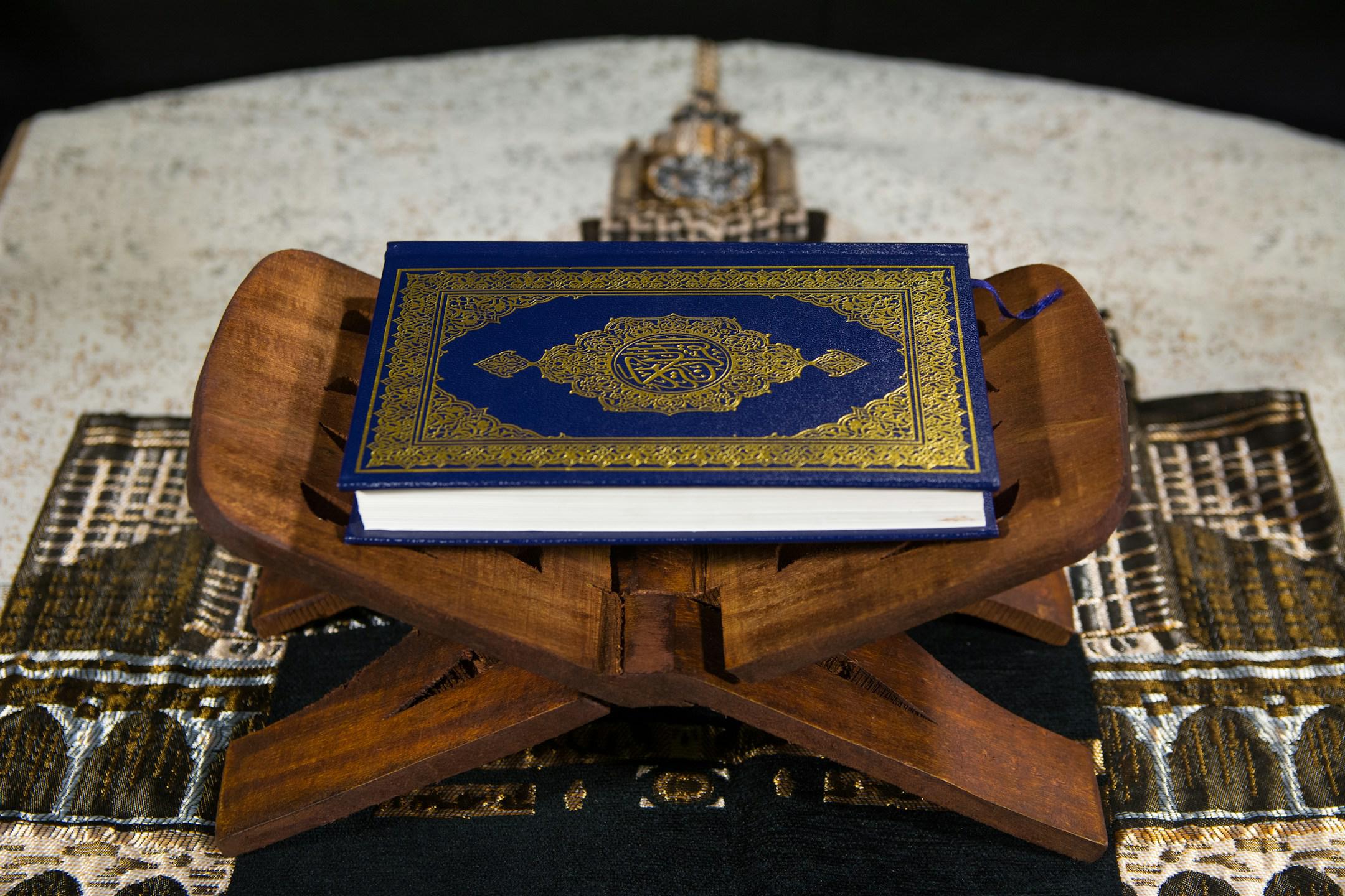 Muslims Islamic Holy Book Quran Majid with Quran wooden stand and Janamaz Prayer Rug in the background4
