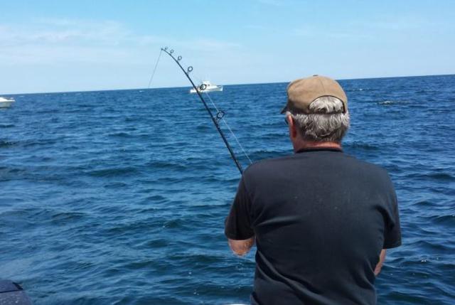 man in black t shirt and hat deep sea fishing