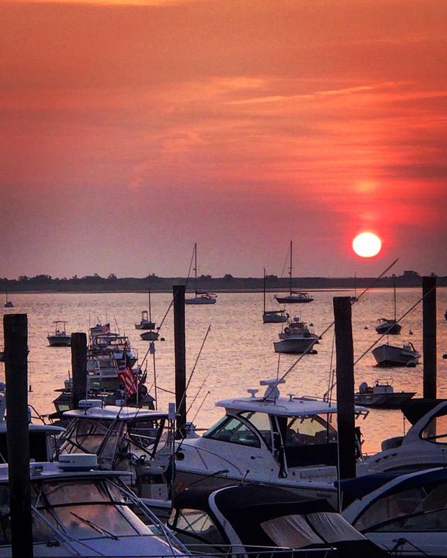 fishing boats docked in harbor at sunset