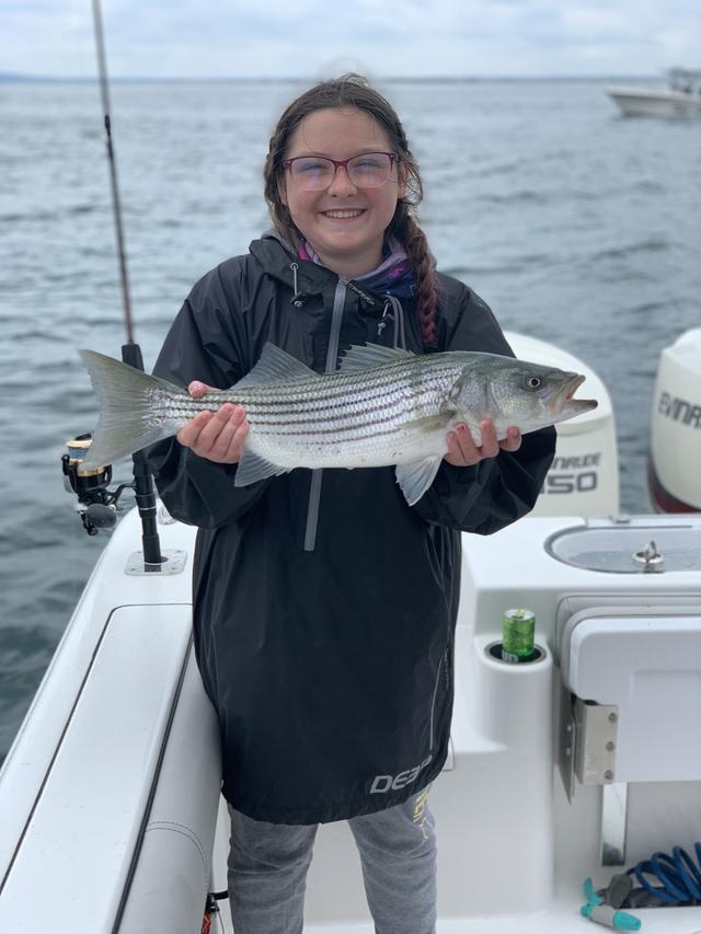young lady holding a fish and smiling
