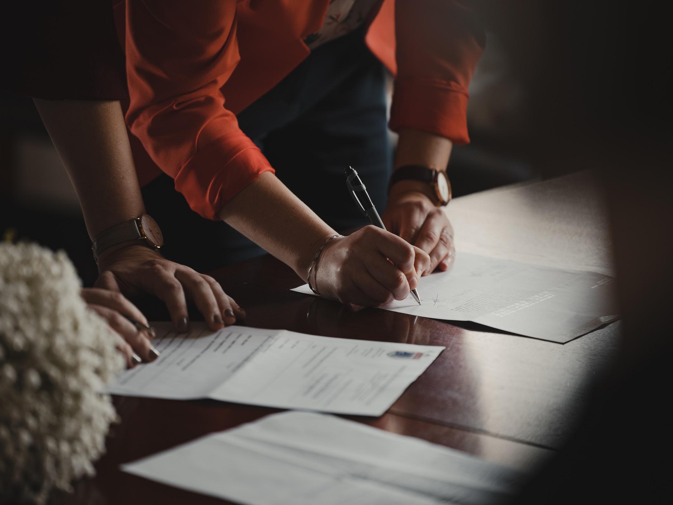 Image of people signing paperwork for filing bankruptcy in Michigan.