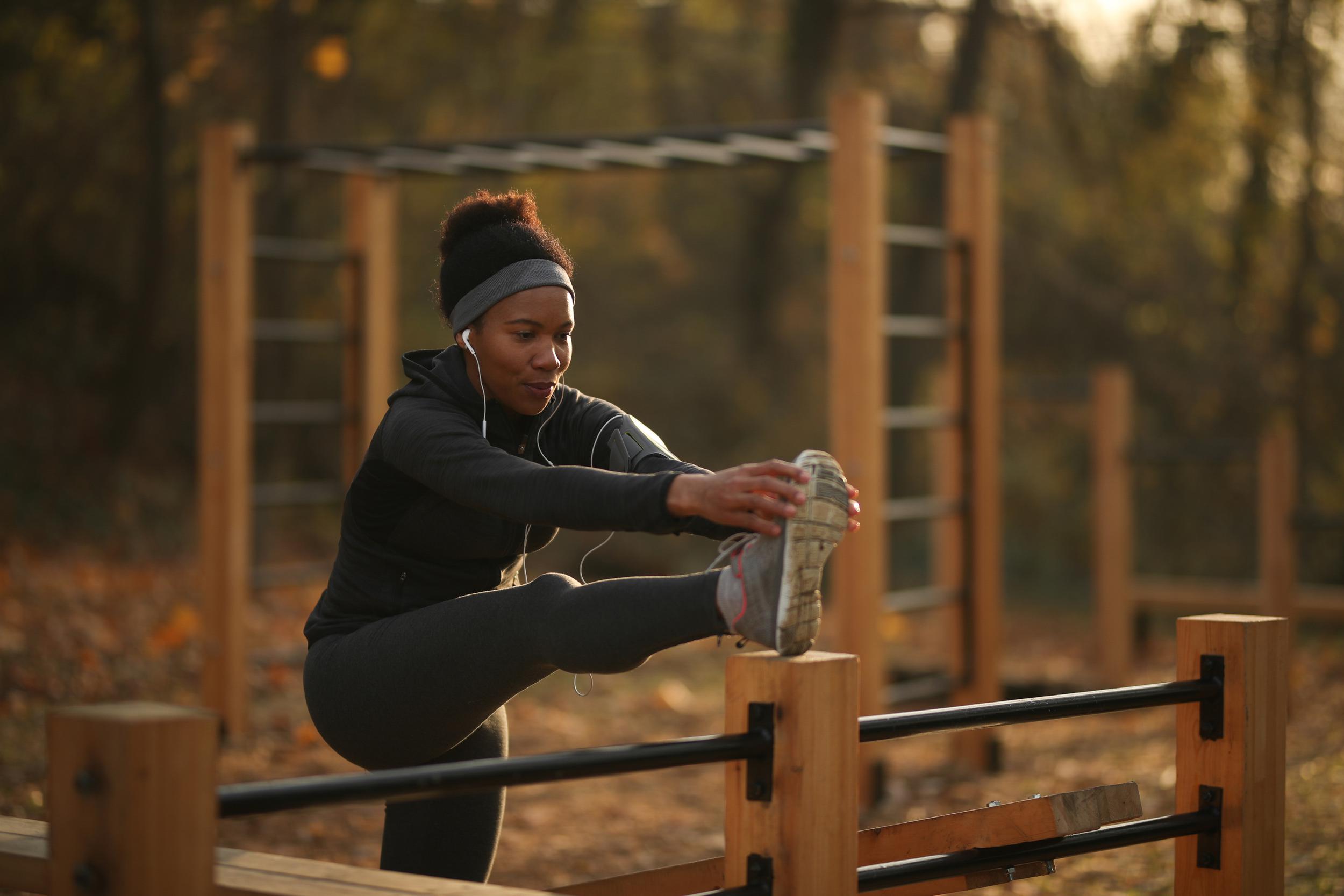 african-american-sportswoman-doing-stretching-exercise-outdoor-gym-nature.jpg