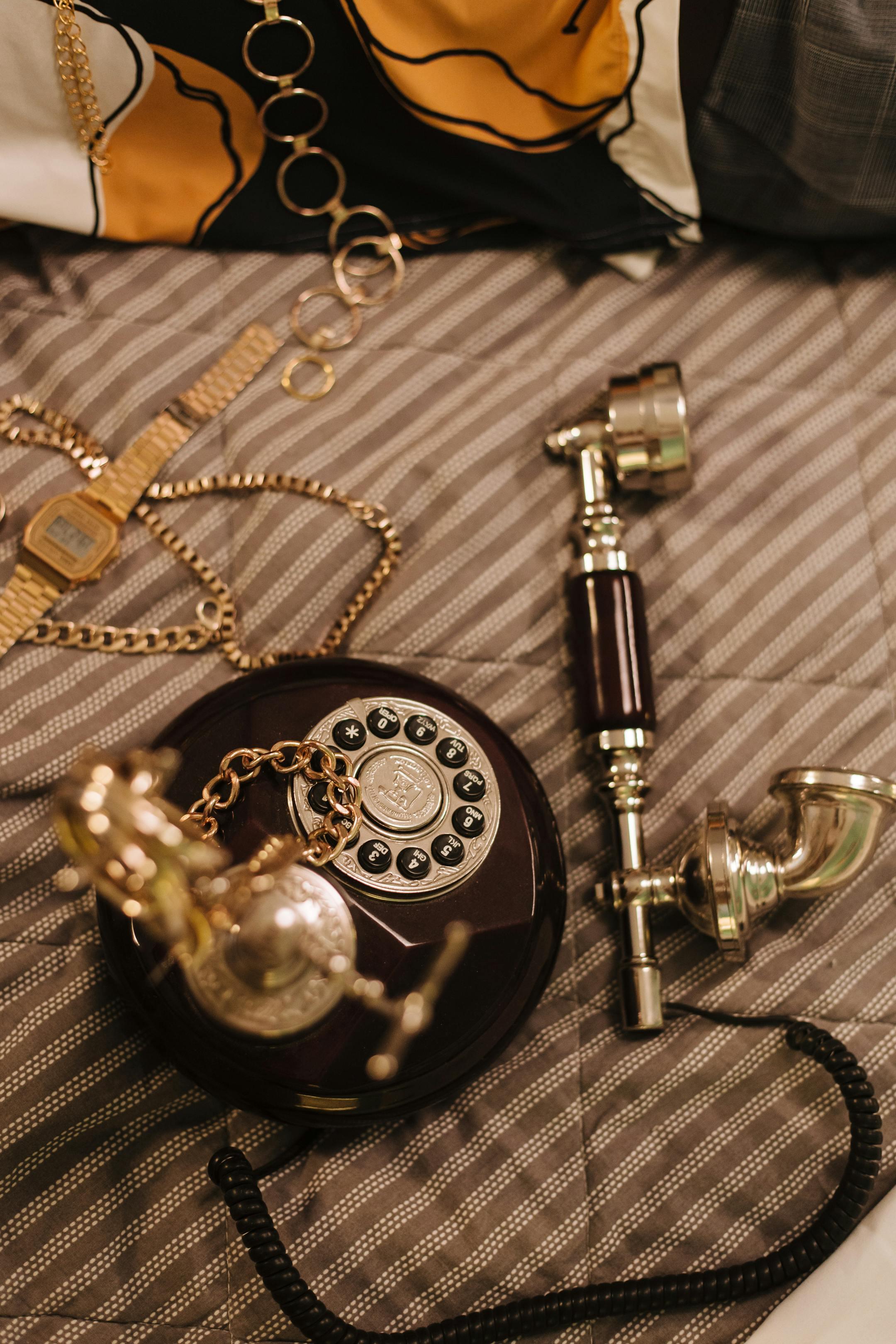 An elegant vintage rotary phone accompanied by stylish accessories, conveying nostalgic vibes.
