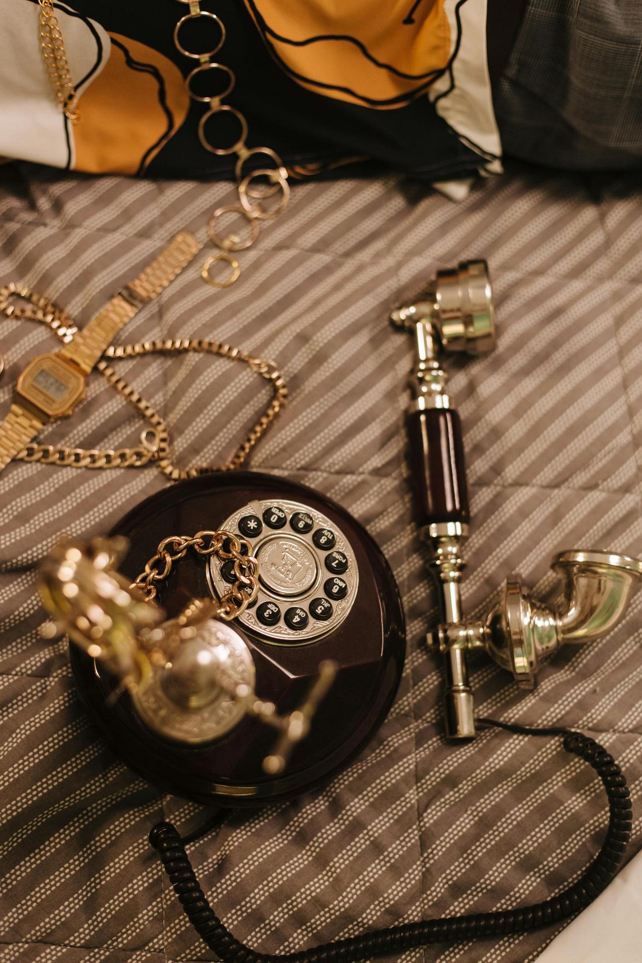 An elegant vintage rotary phone accompanied by stylish accessories, conveying nostalgic vibes.