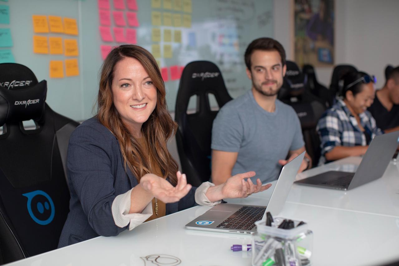 Sales woman in office meeting with laptop