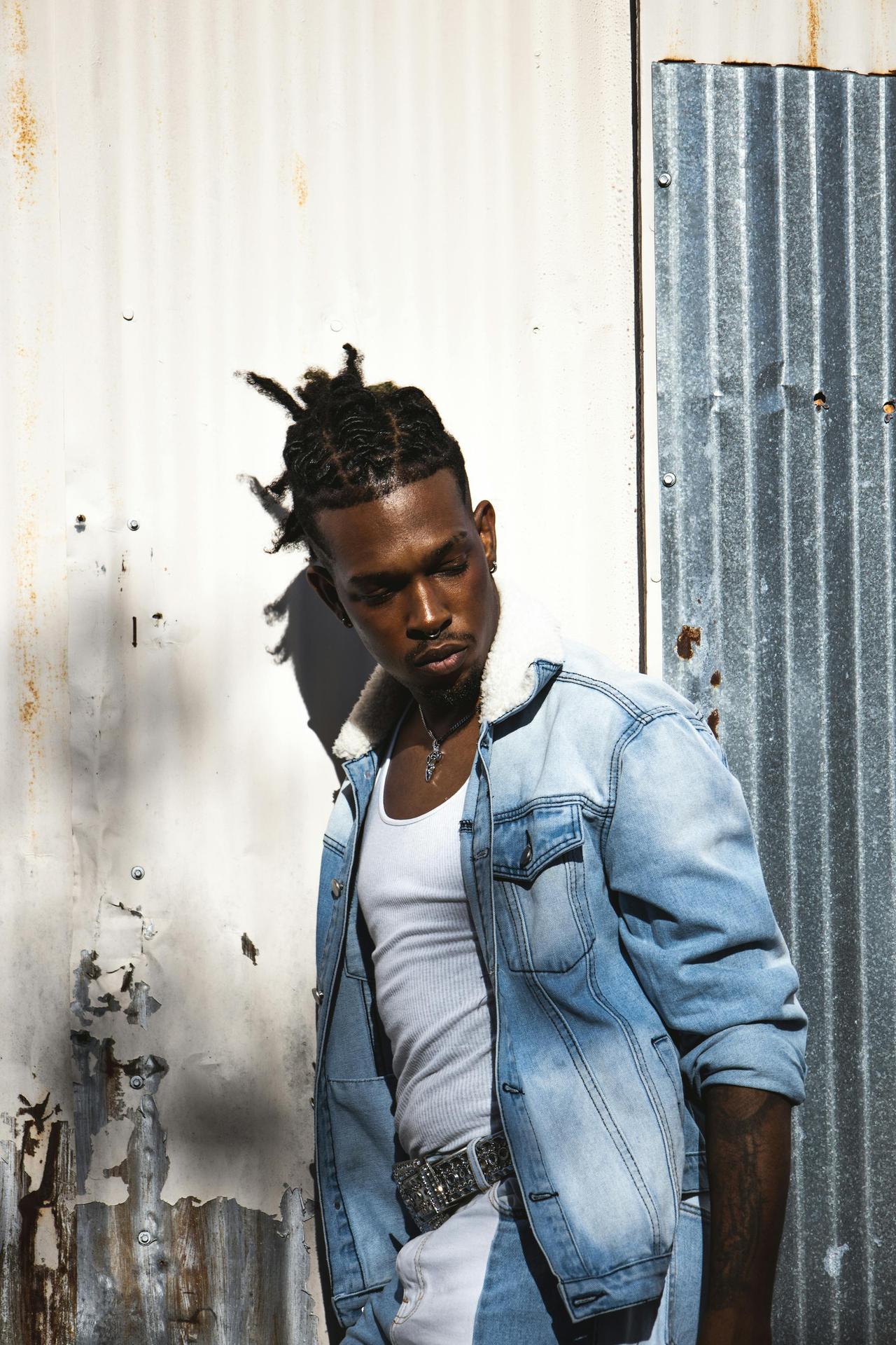Urban portrait of a fashionable young man in a denim jacket outdoors.