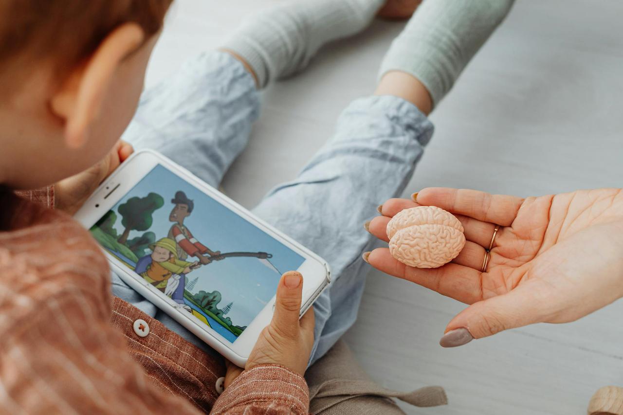 A child watches a cartoon on a smartphone indoors.