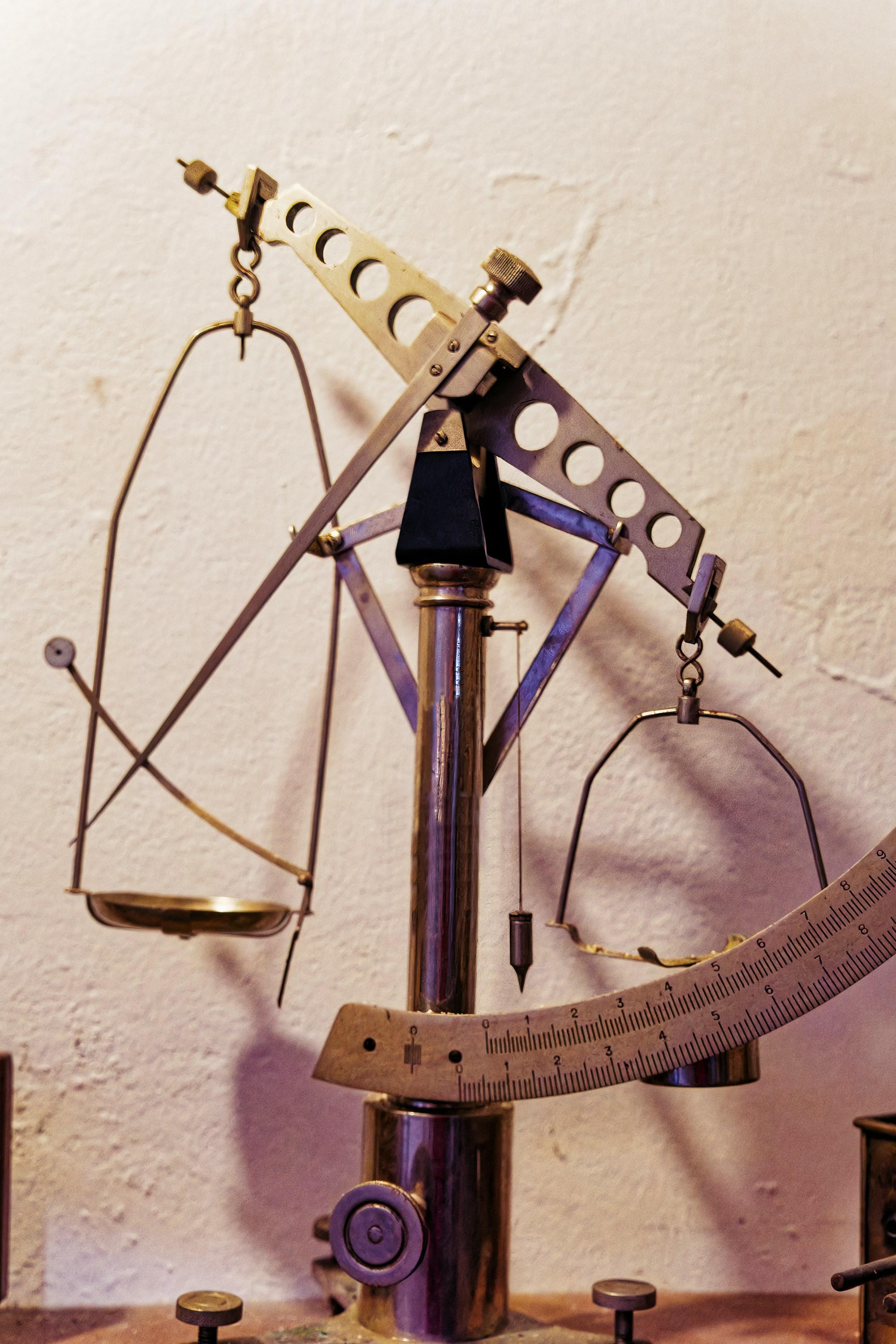 Antique balance scale displayed in a vintage laboratory setting with meticulous craftsmanship - An elegant antique balance scale stands in a vintage laboratory, showcasing its finely crafted metal components and intricate design.