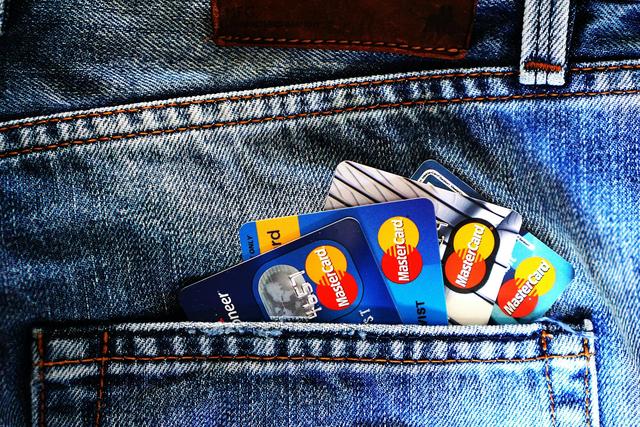 Close-up of a denim pocket with multiple credit cards, illustrating finance and fashion.