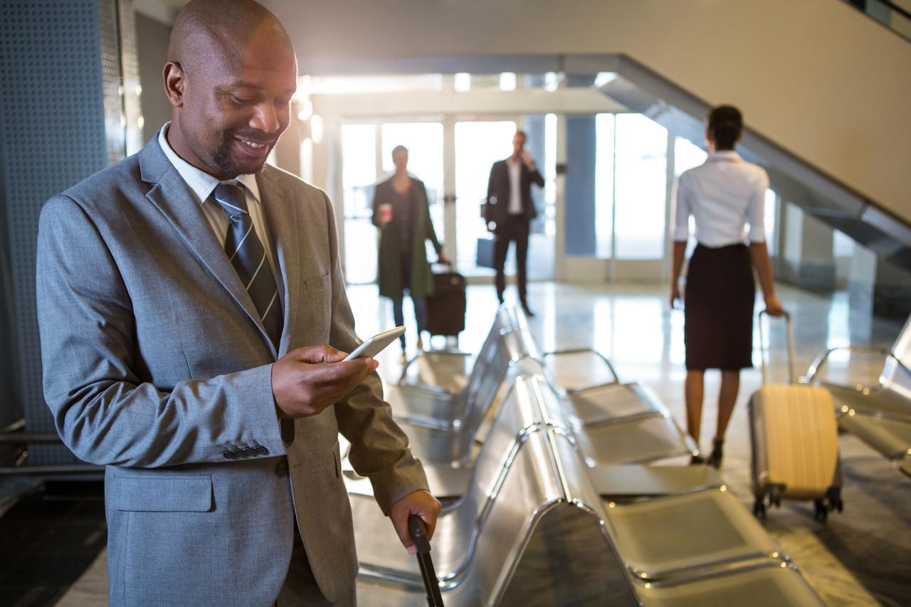 businessman-using-mobile-phone-waiting-area.jpeg