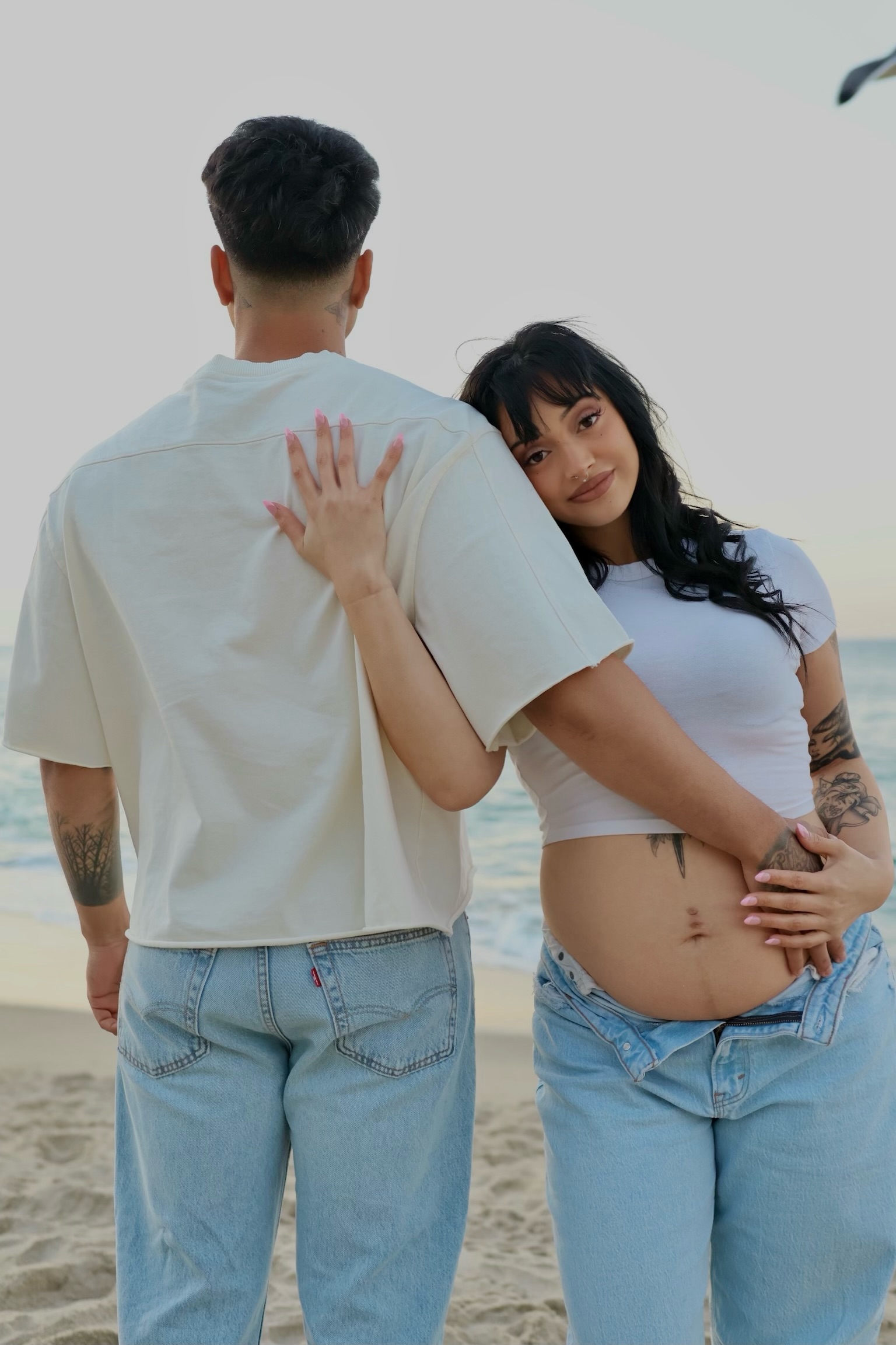 Expecting couple together on the beach.