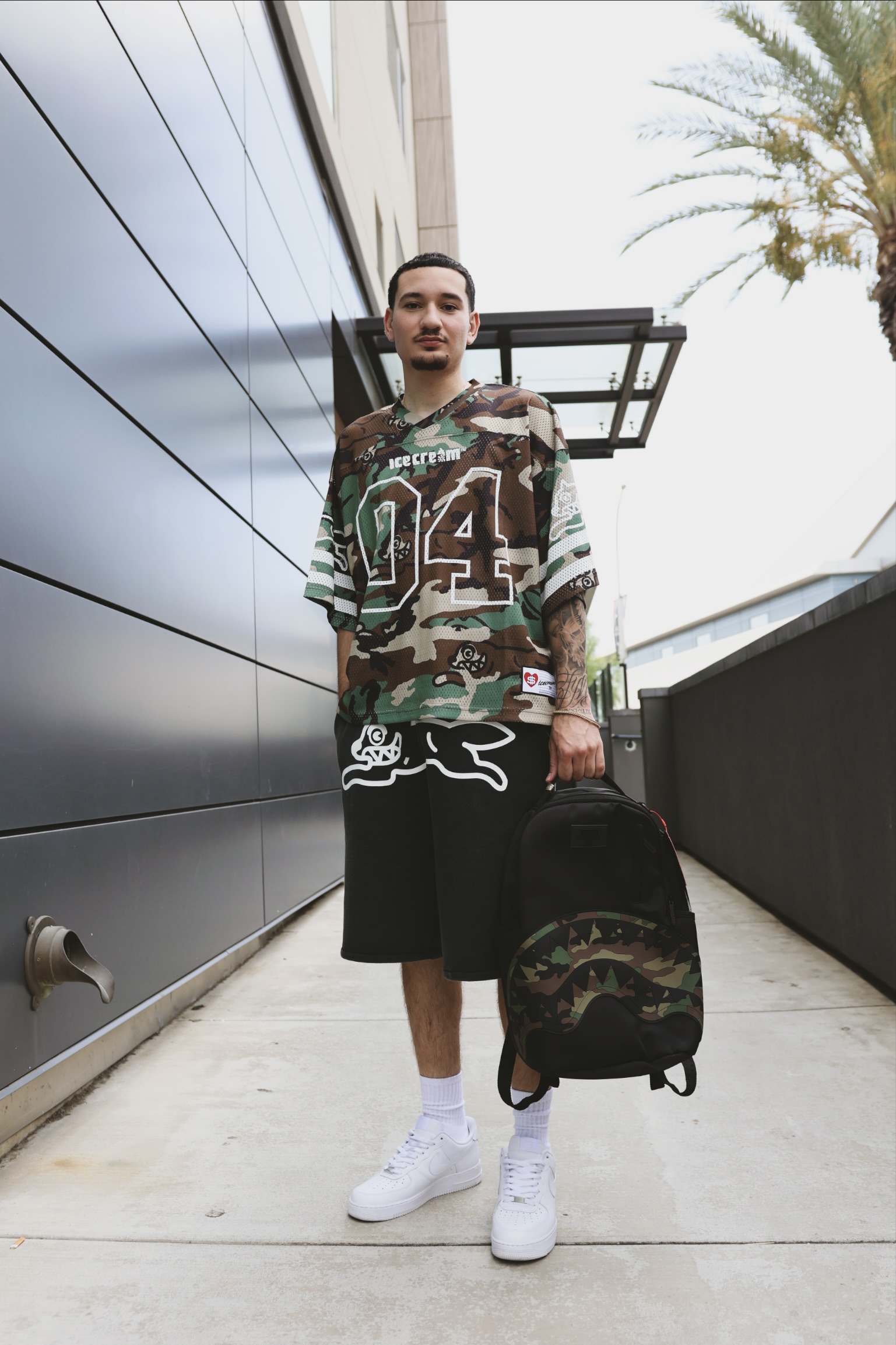 Full-length streetwear portrait in an urban setting.