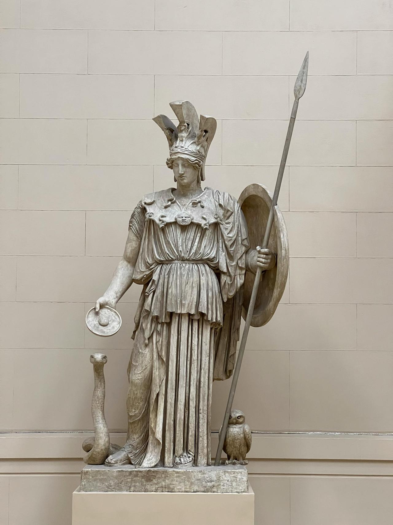 Classic Greek statue of goddess Athena with spear and shield in museum.