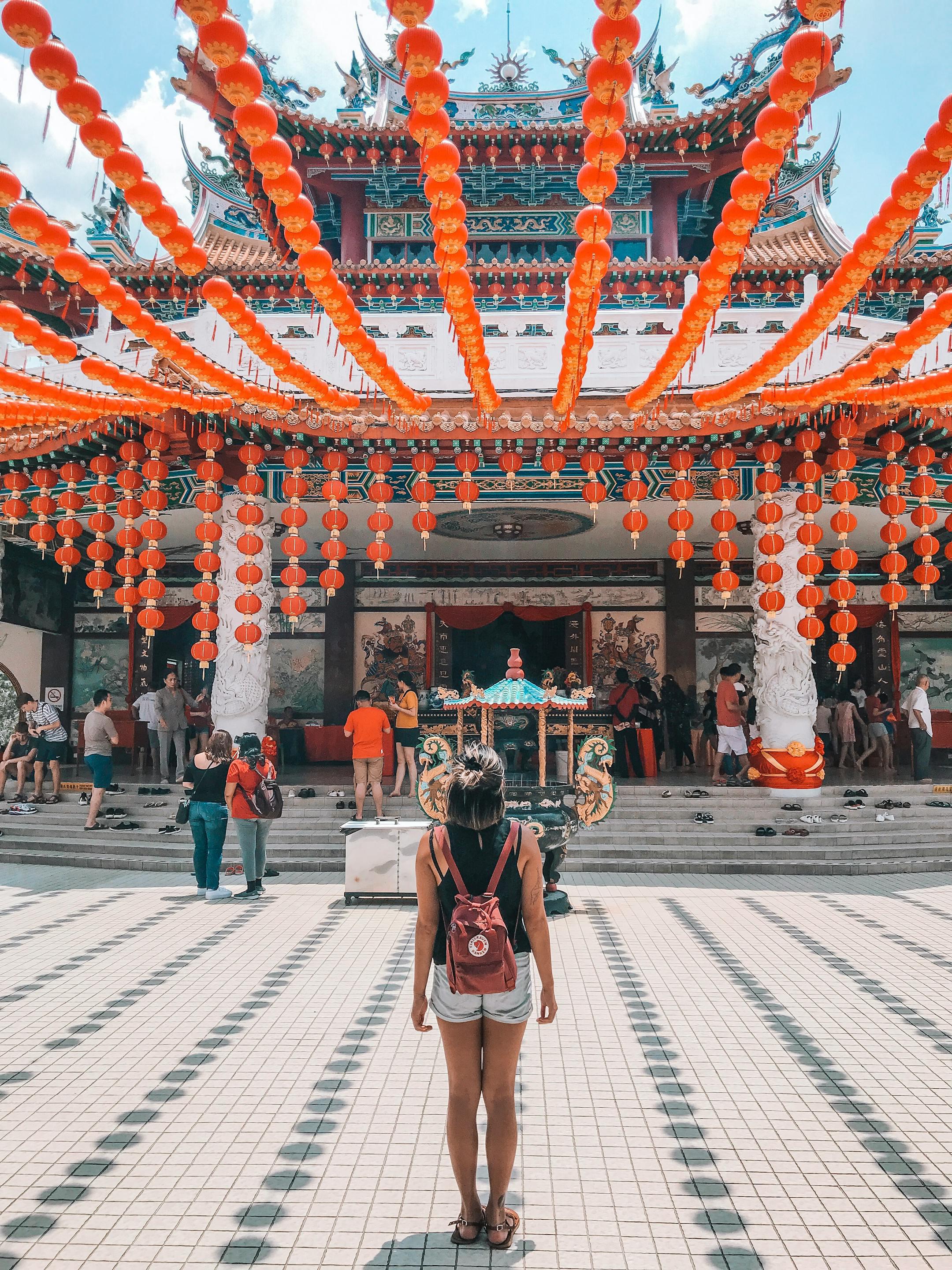 A woman stands amidst vibrant lanterns at Thean Hou Temple in Malaysia.