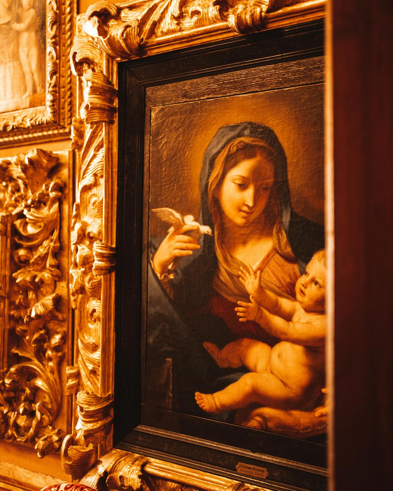 Close-up of Virgin Mary and Child painting surrounded by ornate gold frame in Stresa.