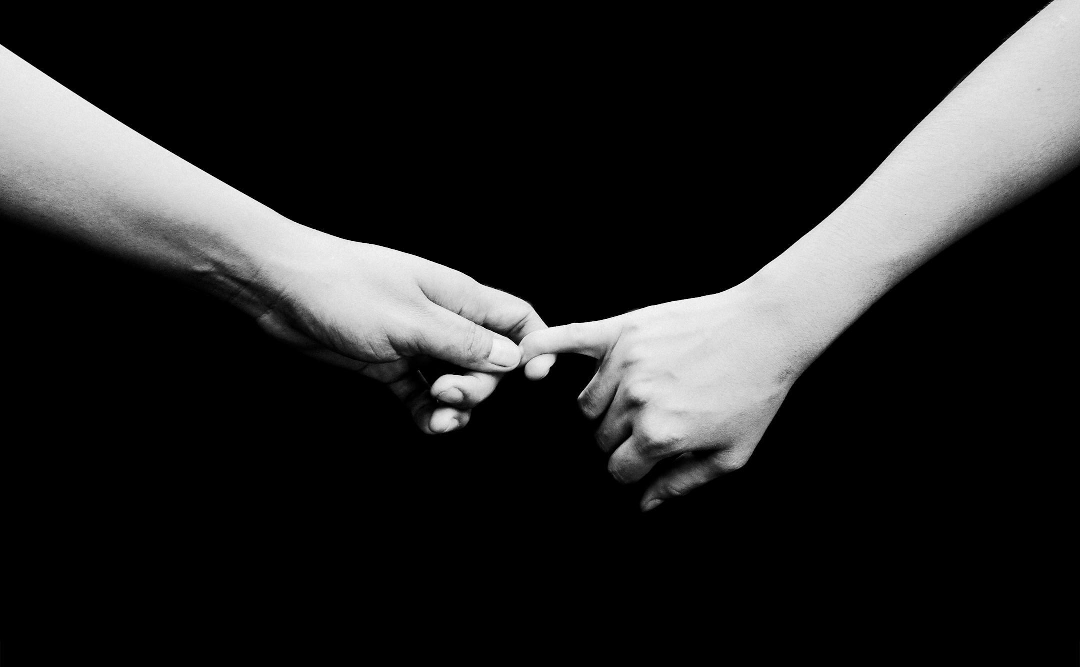 Two hands reaching out in a black and white composition, symbolizing reconnection and emotional healing through Cognitive Analytica couples therapy in Lebanon