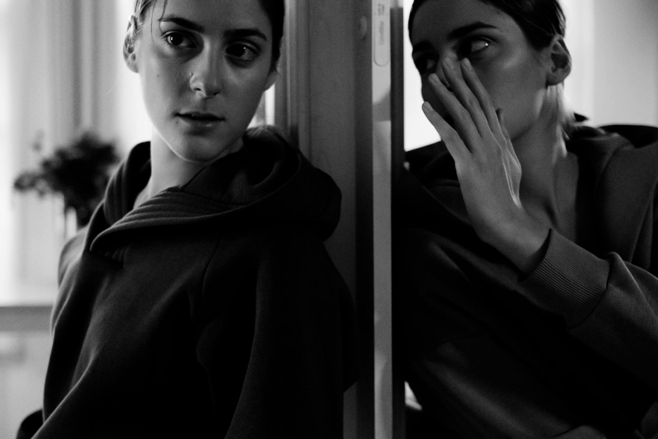 Black and white portrait of a woman in deep thought, whispering to her reflection — symbolizing inner dialogue and emotional struggle — Cognitive Analytica, Lebanon