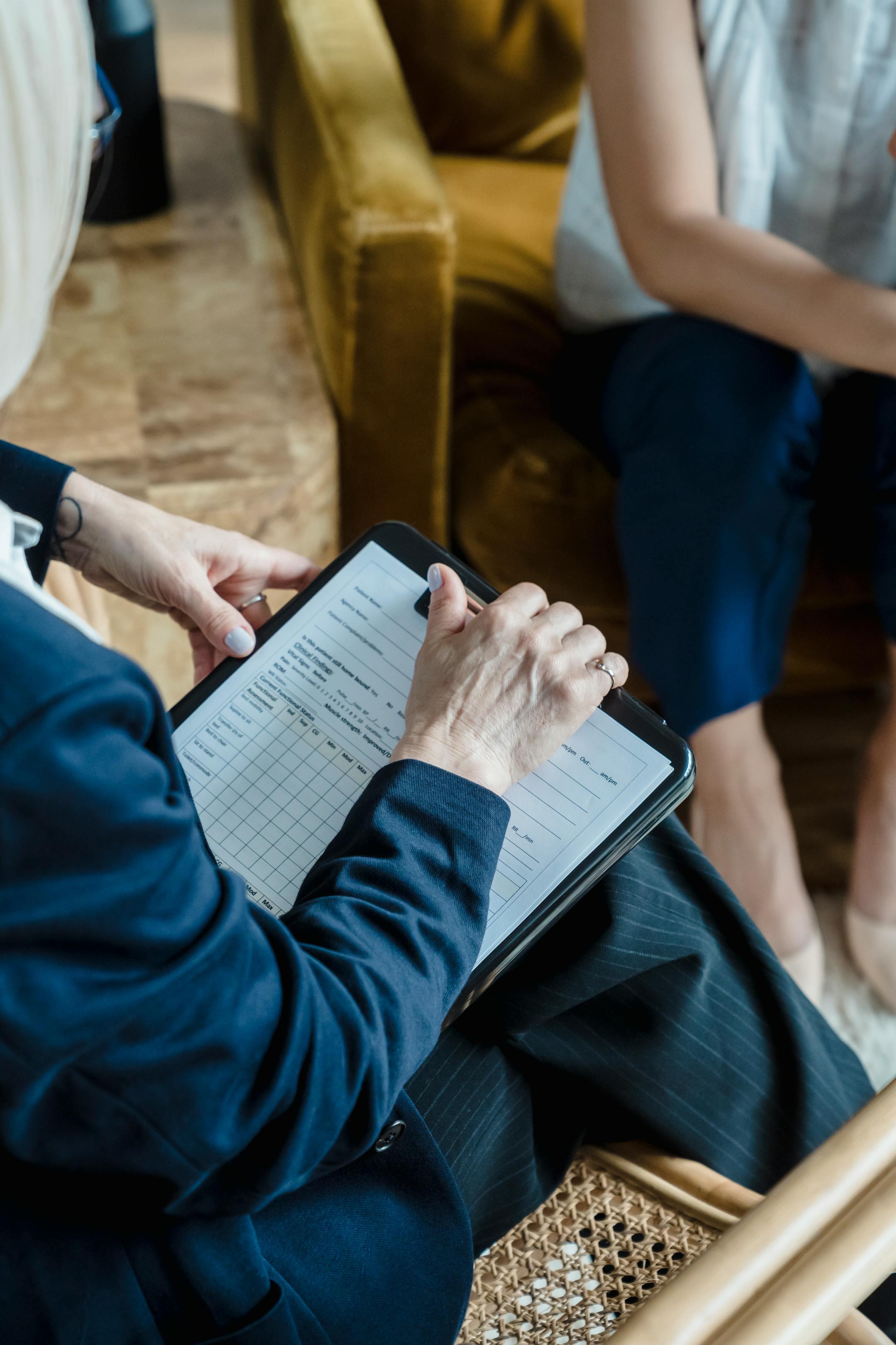 Hands holding a clipboard in a professional setting during a counseling session.