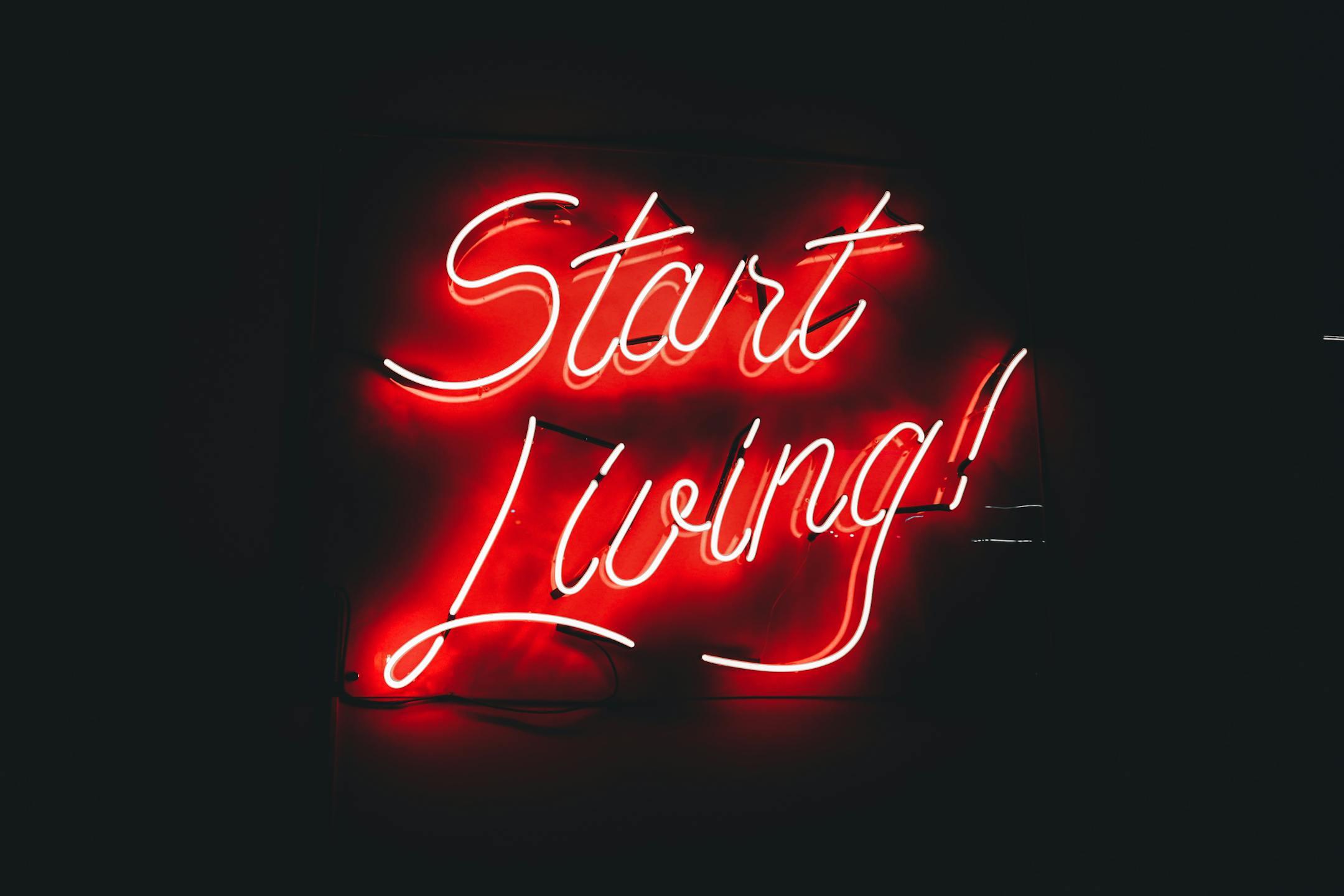 Bold red neon sign that says "Start Living!" — symbolizing emotional healing and the first step toward online therapy in Lebanon.