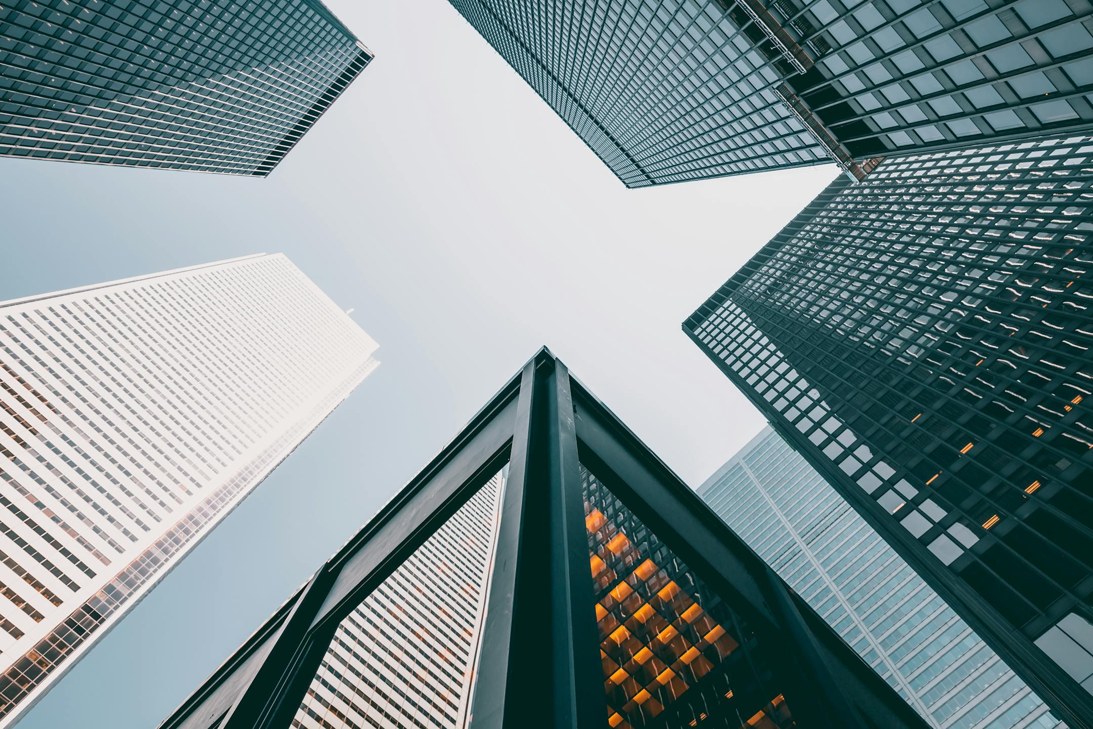 Low angle view of modern skyscrapers with glass facades against a clear sky.