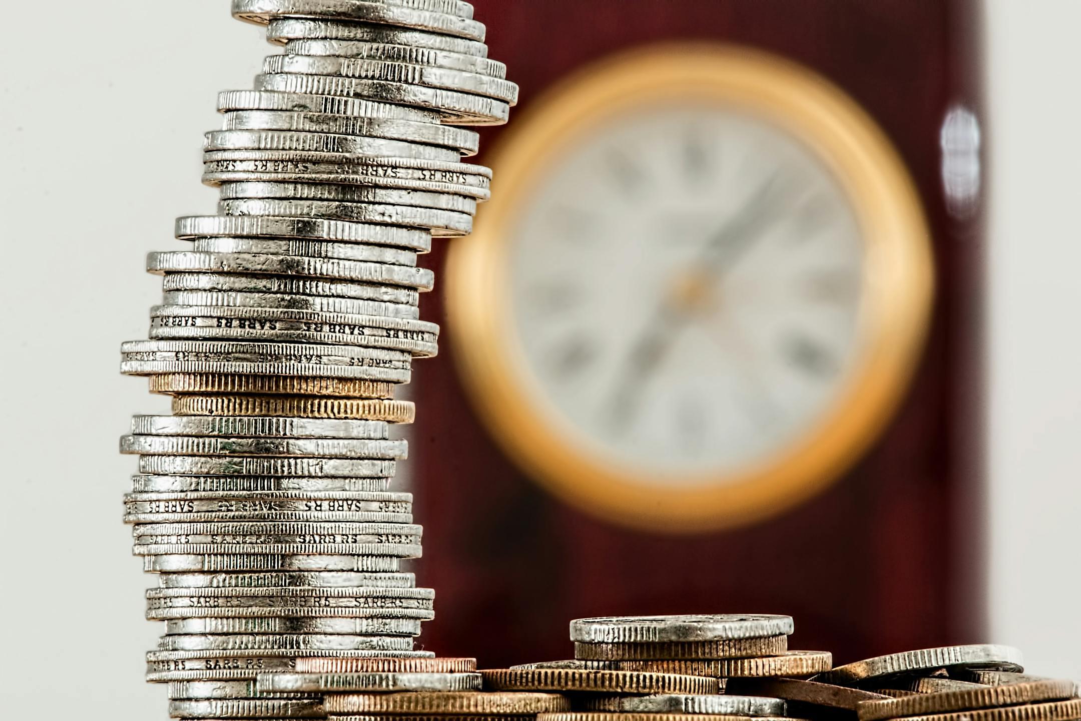 Close-up of stacked coins with a blurred clock in the background, representing the long-term financial and personal cost of delaying affordable therapy with Cognitive Analytica in Lebanon.<blockquote></blockquote>