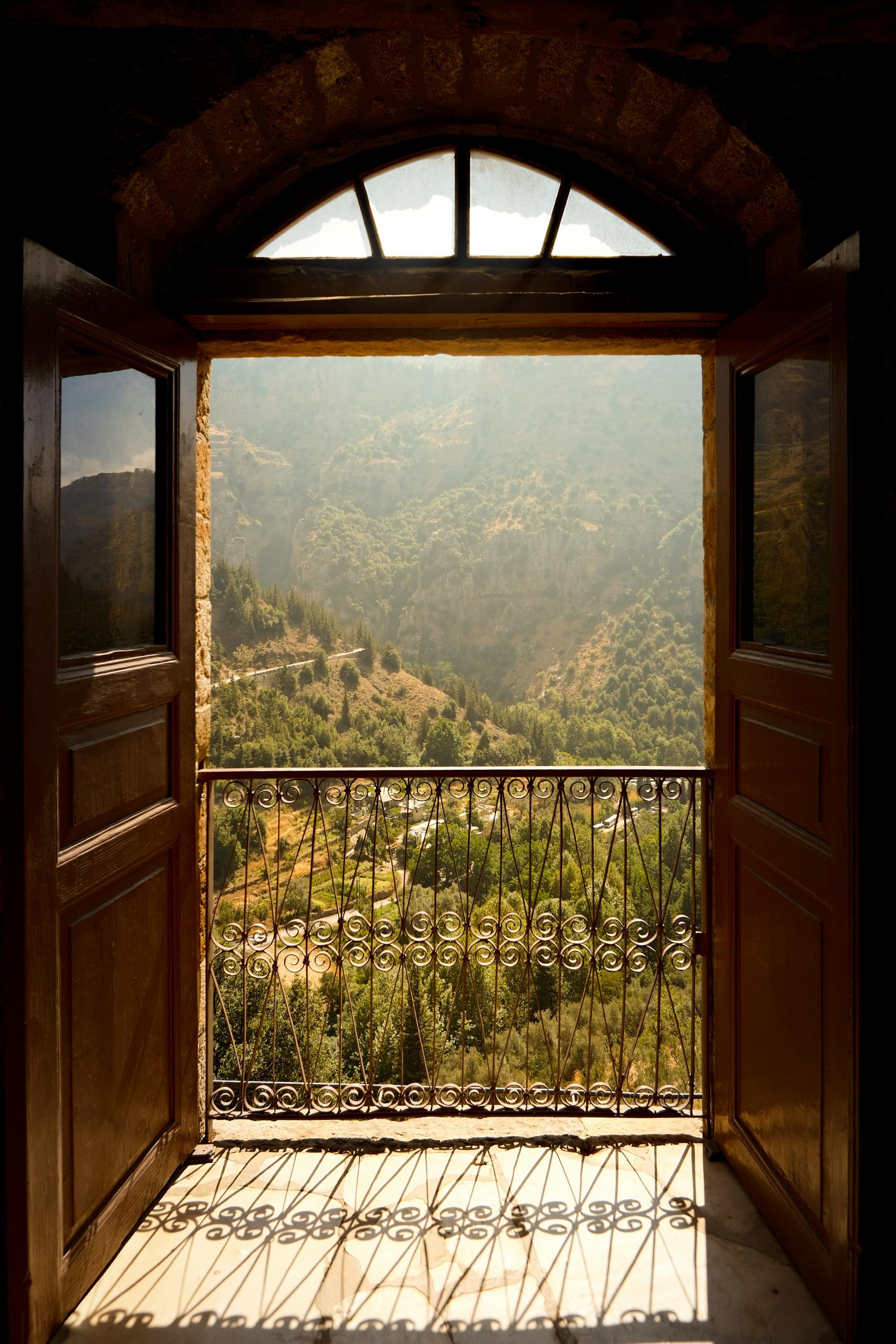 Sunny mountain view framed by a rustic window in Lebanon.