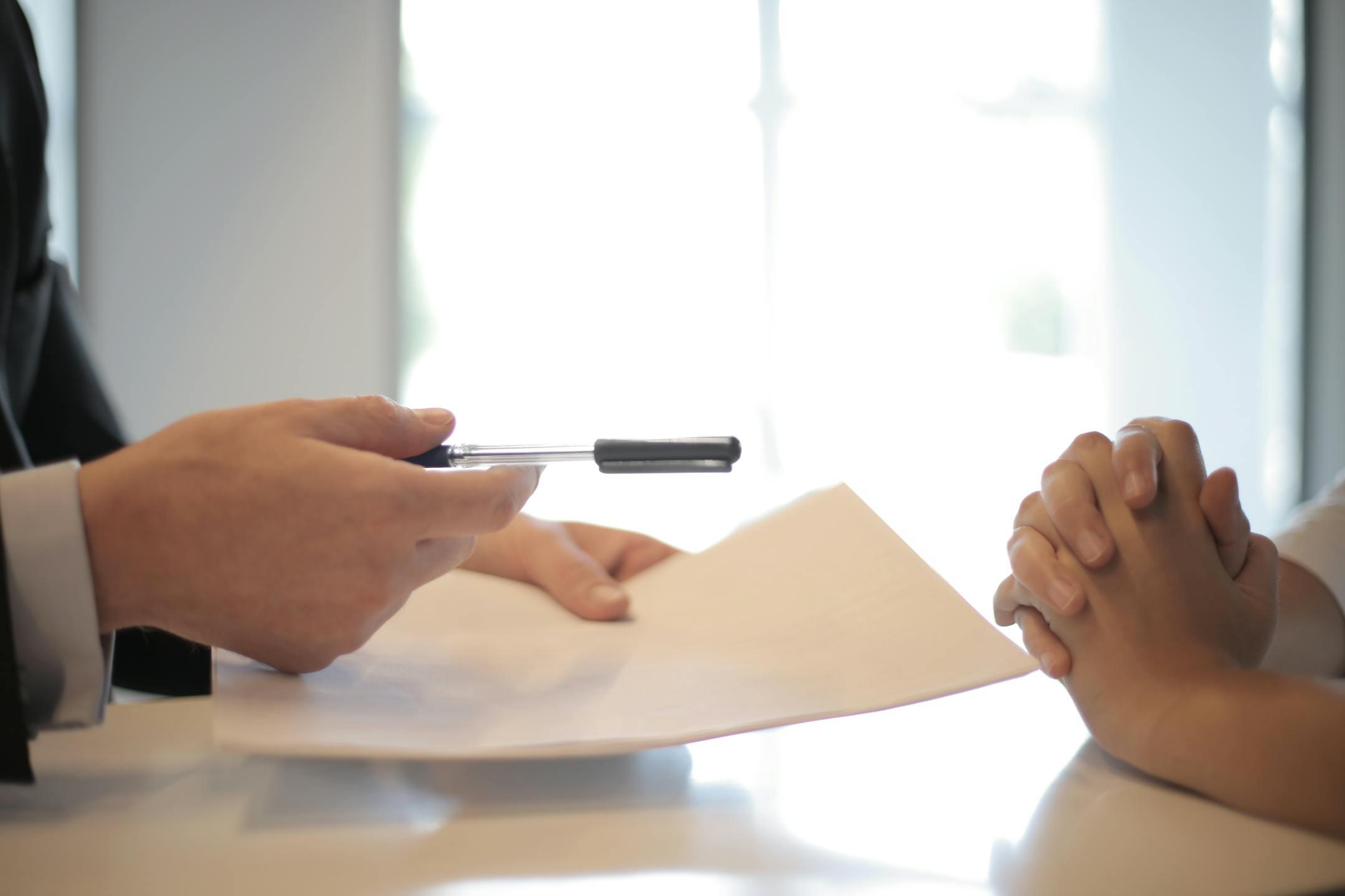 Close-up of hands reviewing and signing therapy-related documents at Cognitive Analytica, symbolizing a clear, structured, and professional therapeutic process.