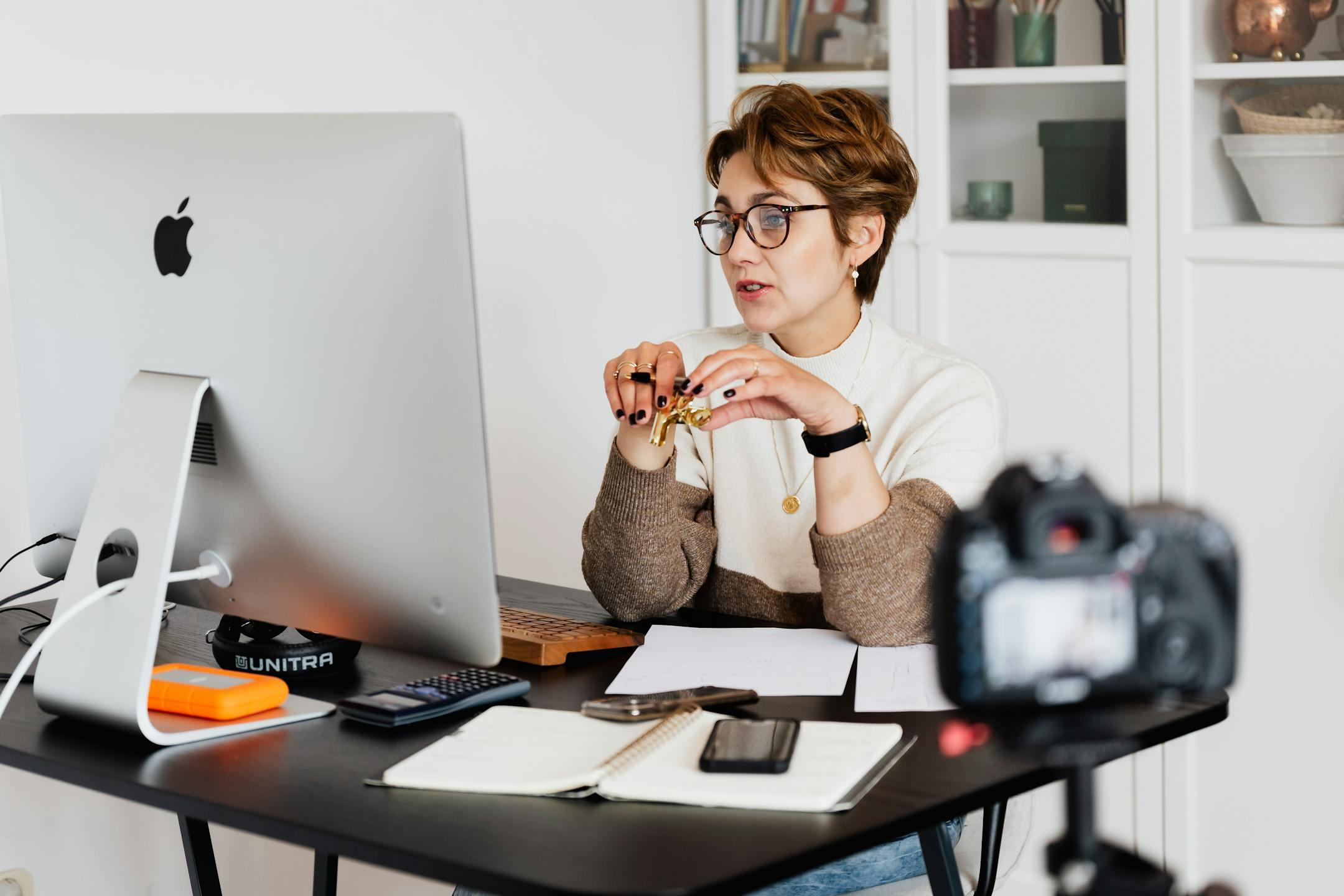 A professional woman engaged in a virtual meeting setup at her home desk, using a computer and camera — representing Cognitive Analytica’s mission to make affordable online therapy accessible across Lebanon.