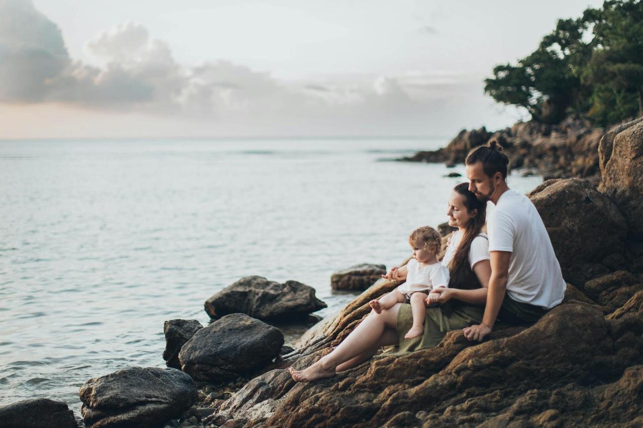 A serene family moment by the seaside at sunset, symbolizing emotional connection, healing, and support through family therapy at Cognitive Analytica