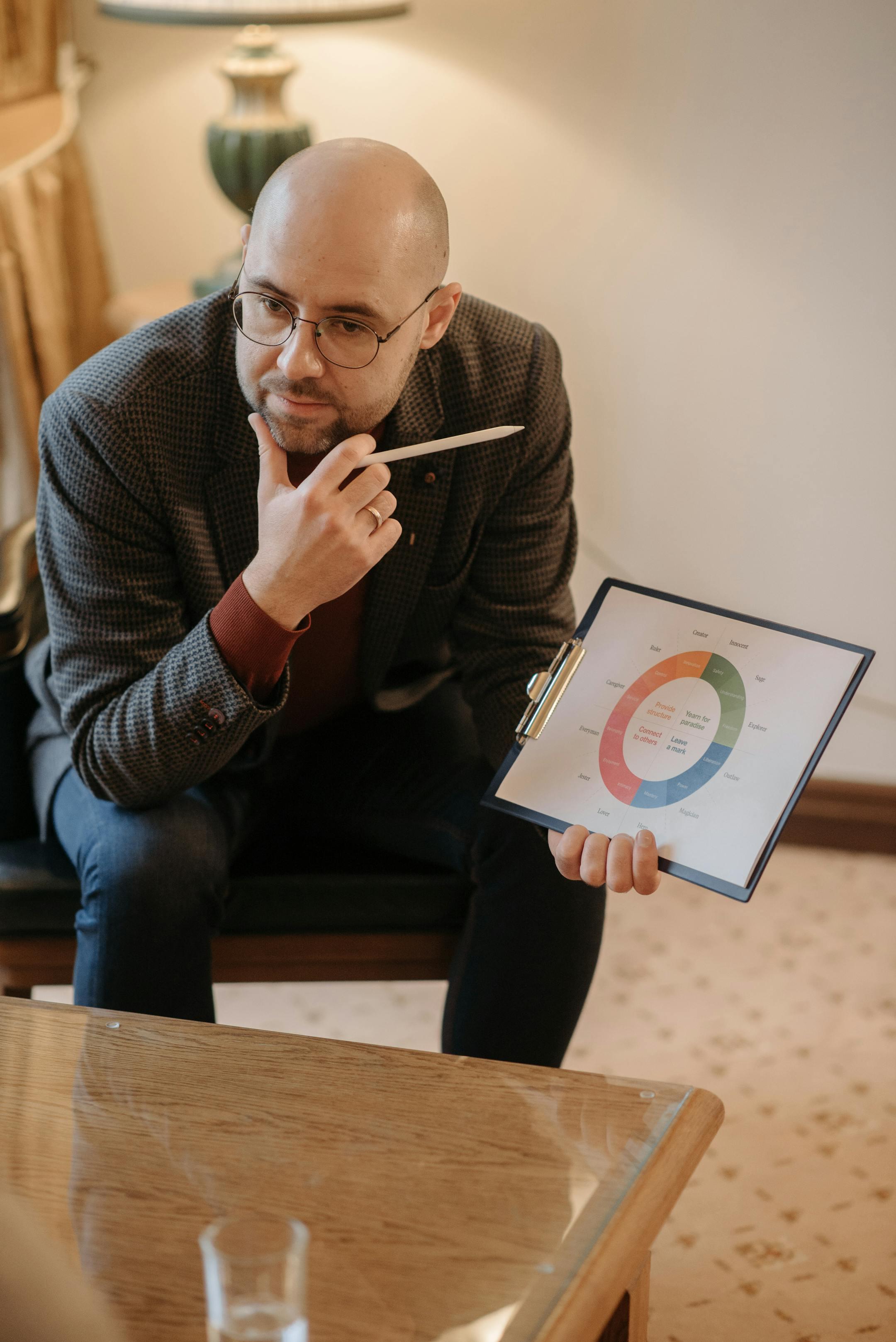 A serious counselor discussing mental health concepts using a chart on a clipboard, representing Cognitive Analytica’s structured and evidence-based psychotherapy approach in Lebanon.